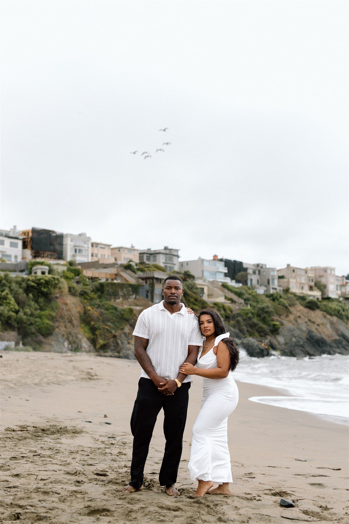 Couple posing for their engagement session at Baker Beach in San Francisco, California, captured by Makayla Miranda Photo