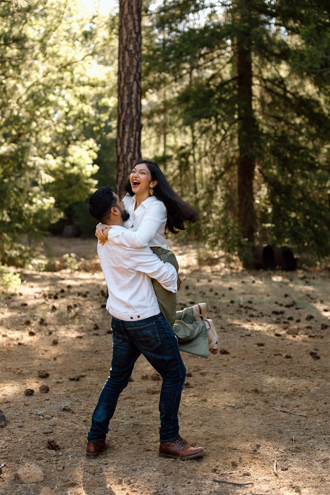 Couple posing for their engagement session at Burney Falls in Northern California, captured by Makayla Miranda Photo.