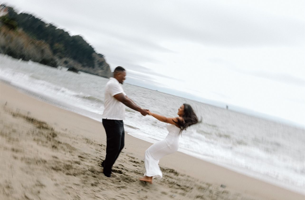 Couple posing for their engagement session at Baker Beach in San Francisco, California, captured by Makayla Miranda Photo