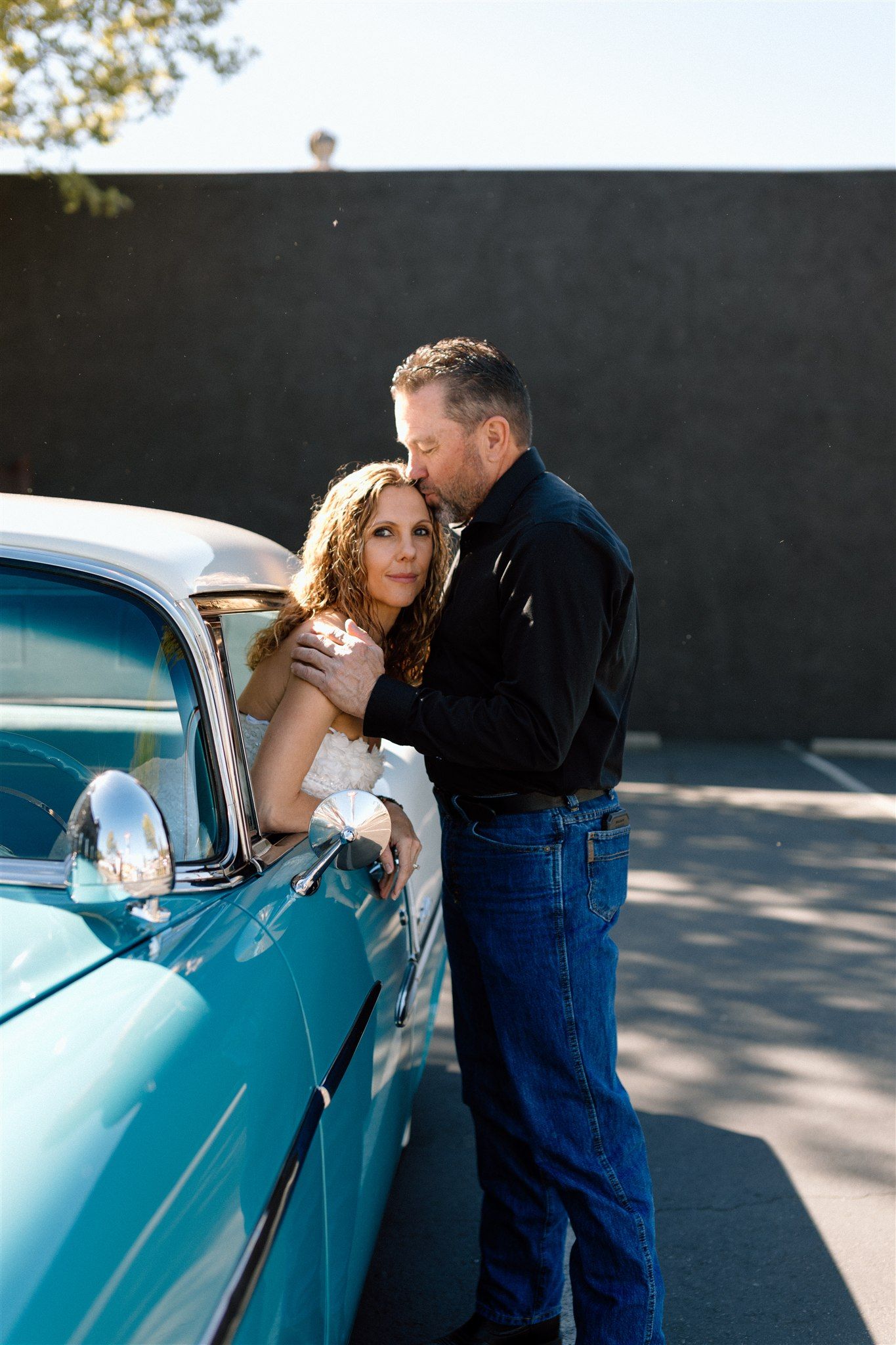 Couple posing with a classic car during their engagement session, captured by Makayla Miranda Photo.
