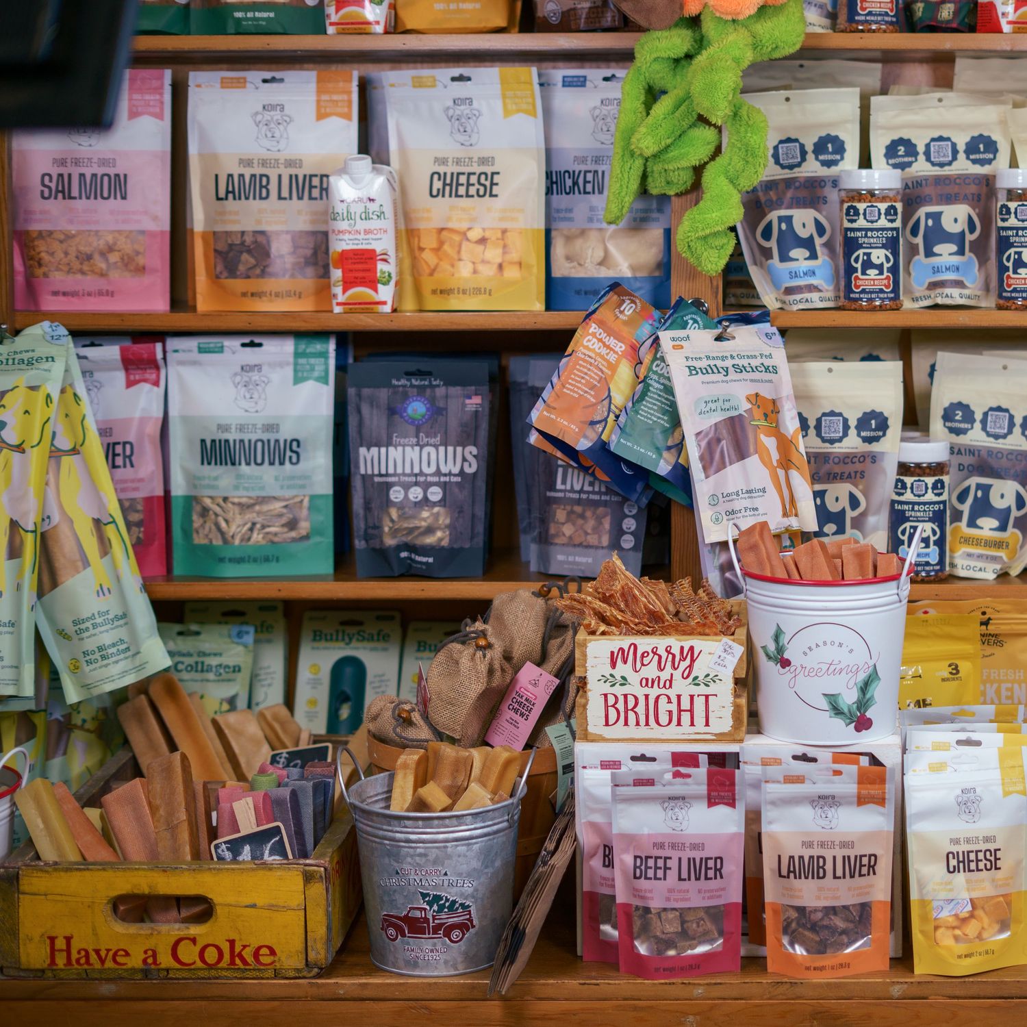 Wooden shelves stocked with assorted natural pet treats and snacks in a pet supply store.