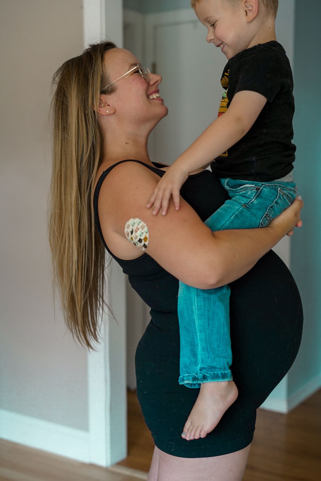maternity family photo. mom holding older son, 30 weeks pregnant. in-home photography session.