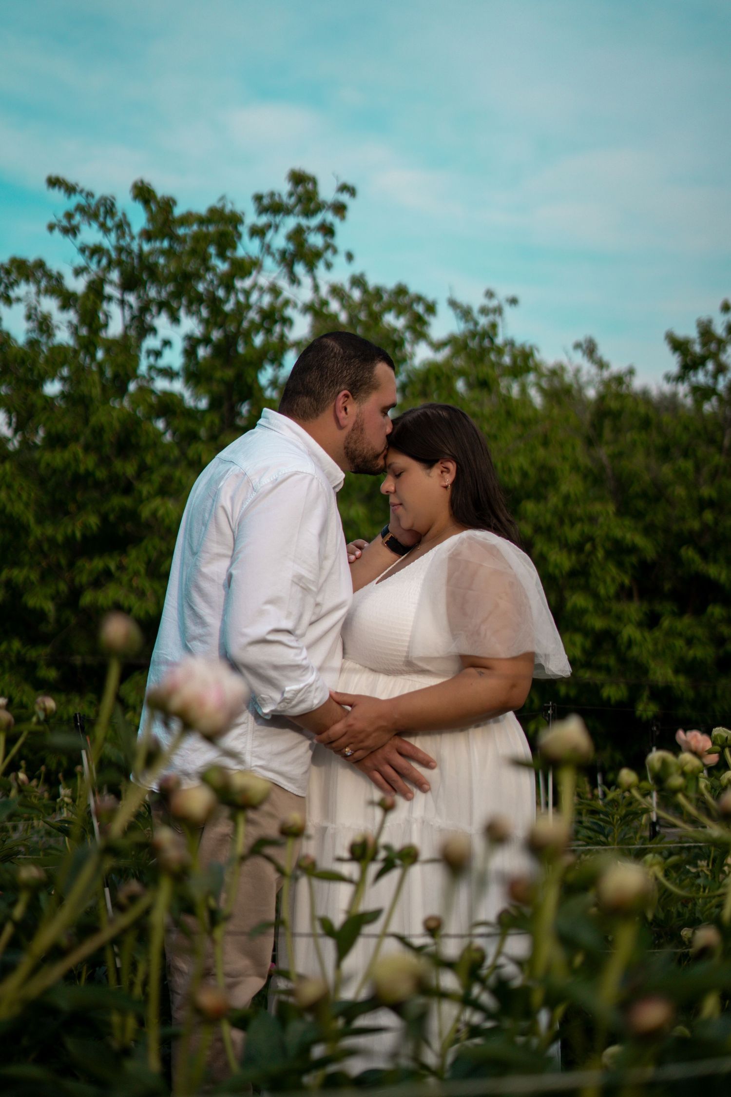 maternity photography couple posed in peony flower field in Bolton, MA