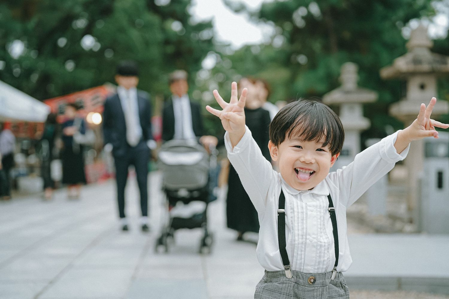 神社で元気いっぱいに手を広げる男の子の記念写真