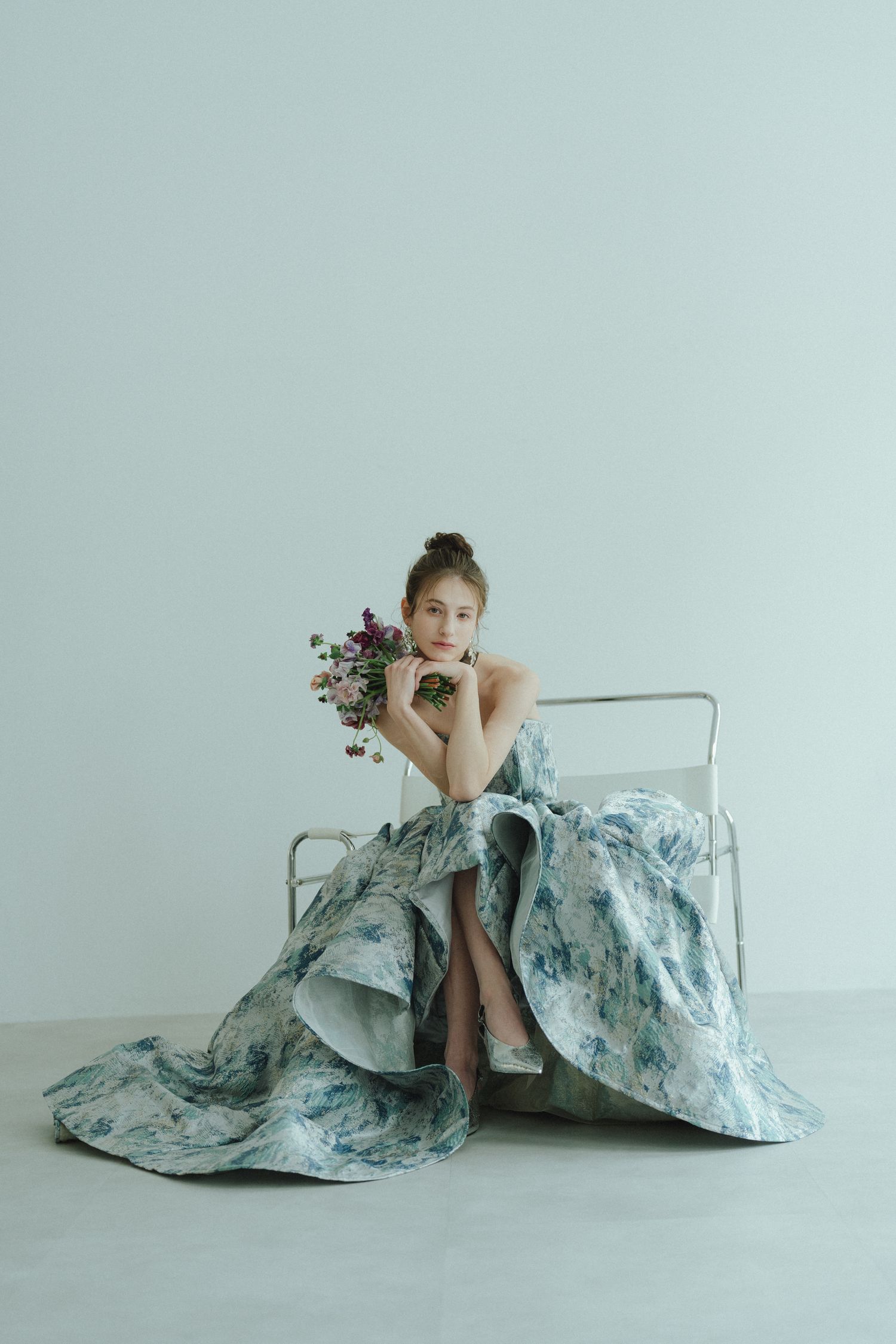 ブーケを手に椅子へ座る花嫁の前撮りポートレート
