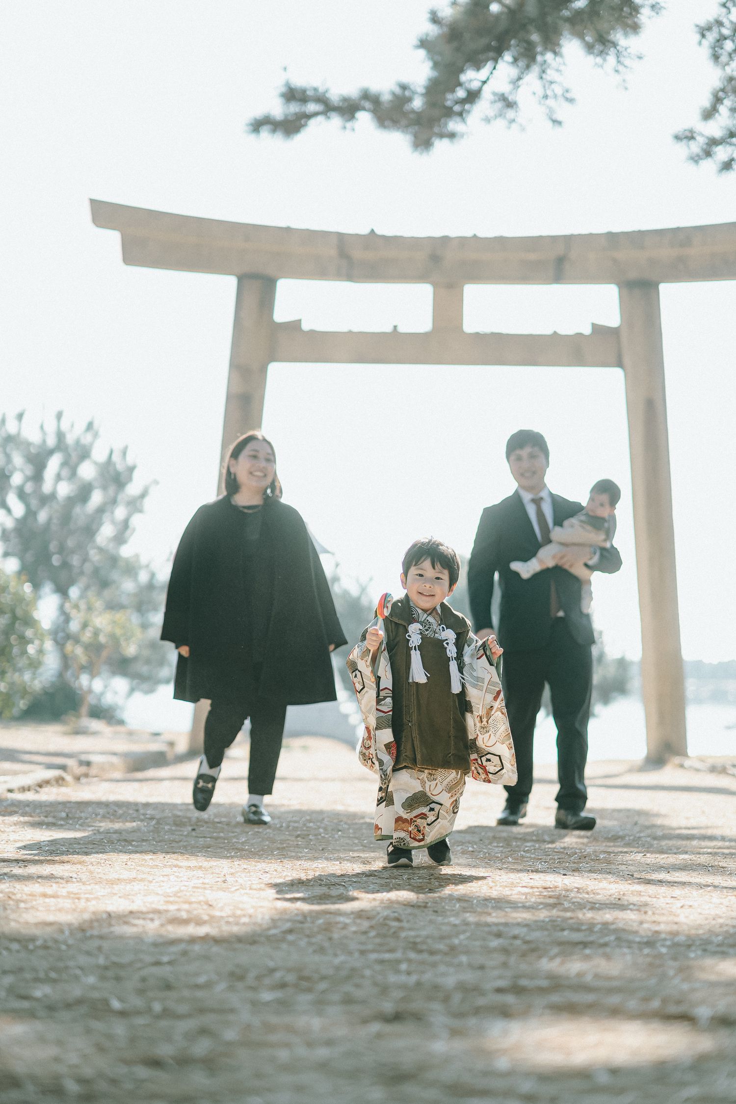 鳥居の前を歩くご家族の晴れやかな記念写真