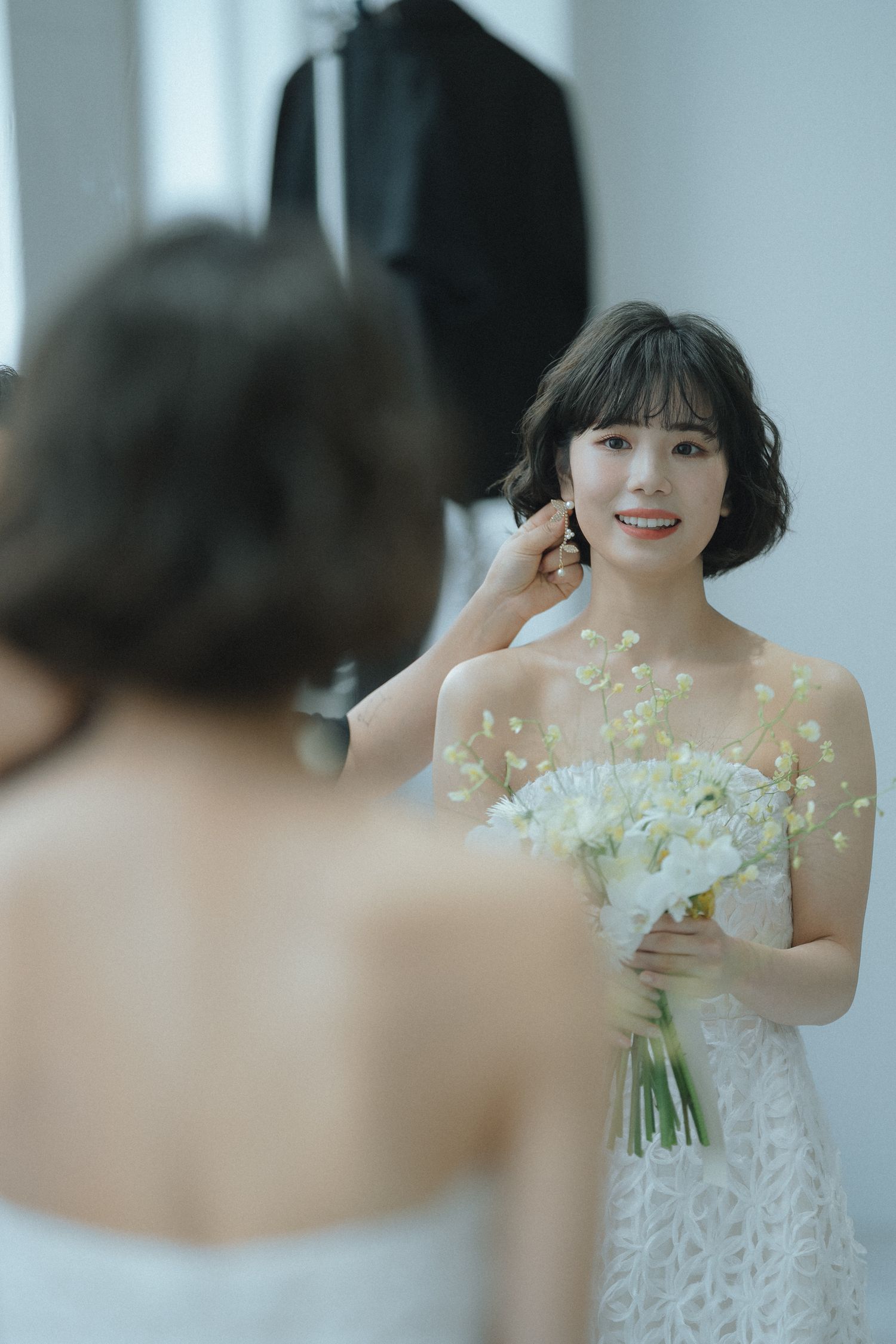 鏡越しに笑顔を見せる花嫁のやわらかなポートレート