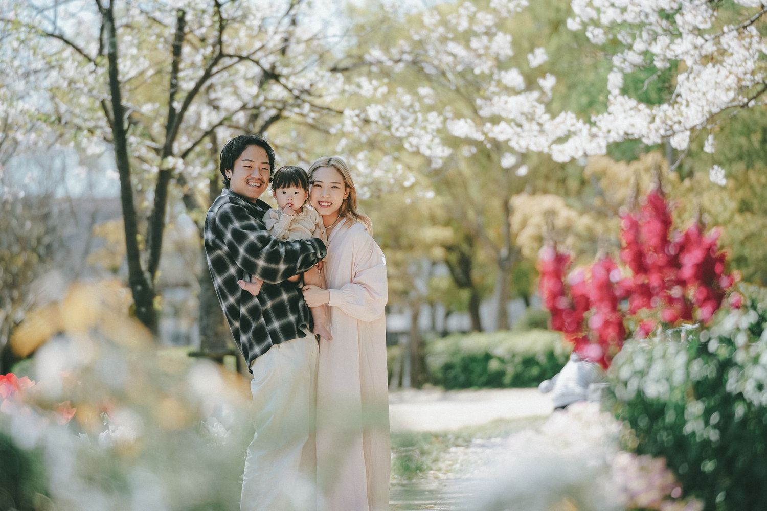 花々に囲まれて寄り添う小さなお子様とご夫婦のやさしいポートレート