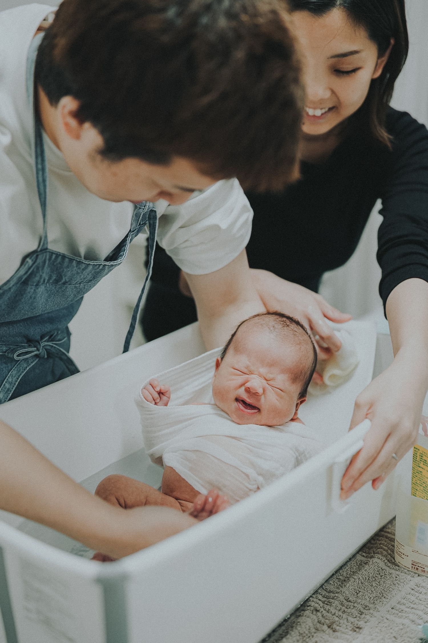 生まれたばかりの赤ちゃんを囲むご家族のあたたかな記念写真