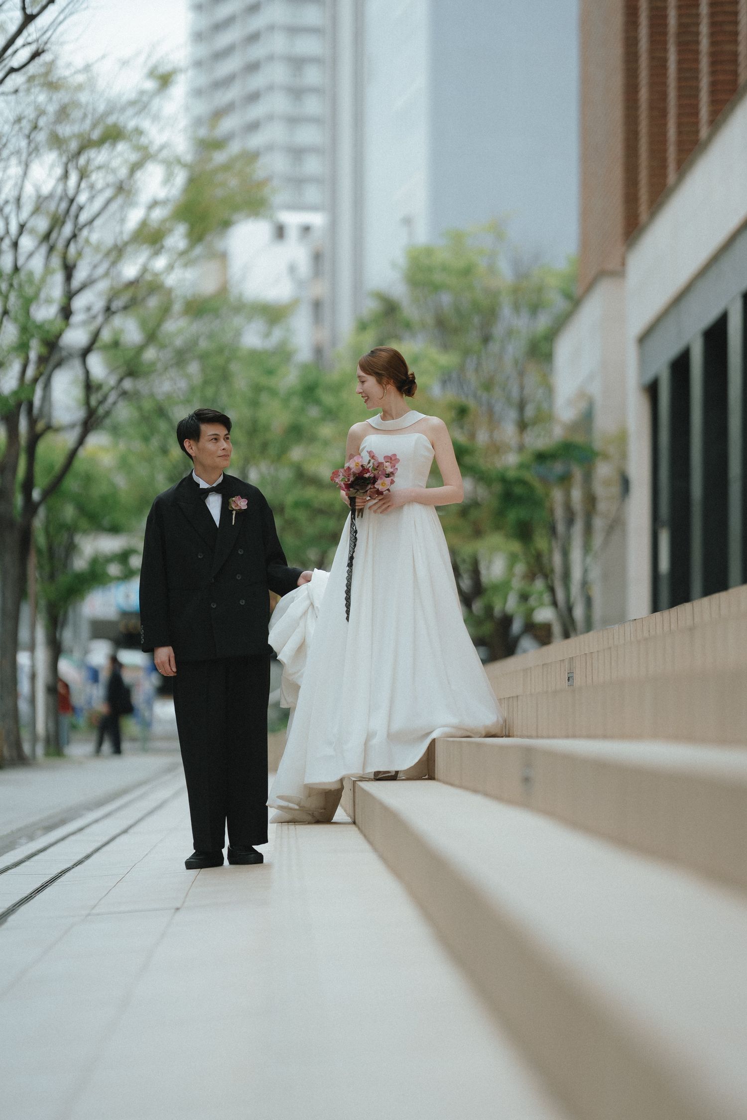 階段に並んで立つご夫婦のやさしいウェディングフォト