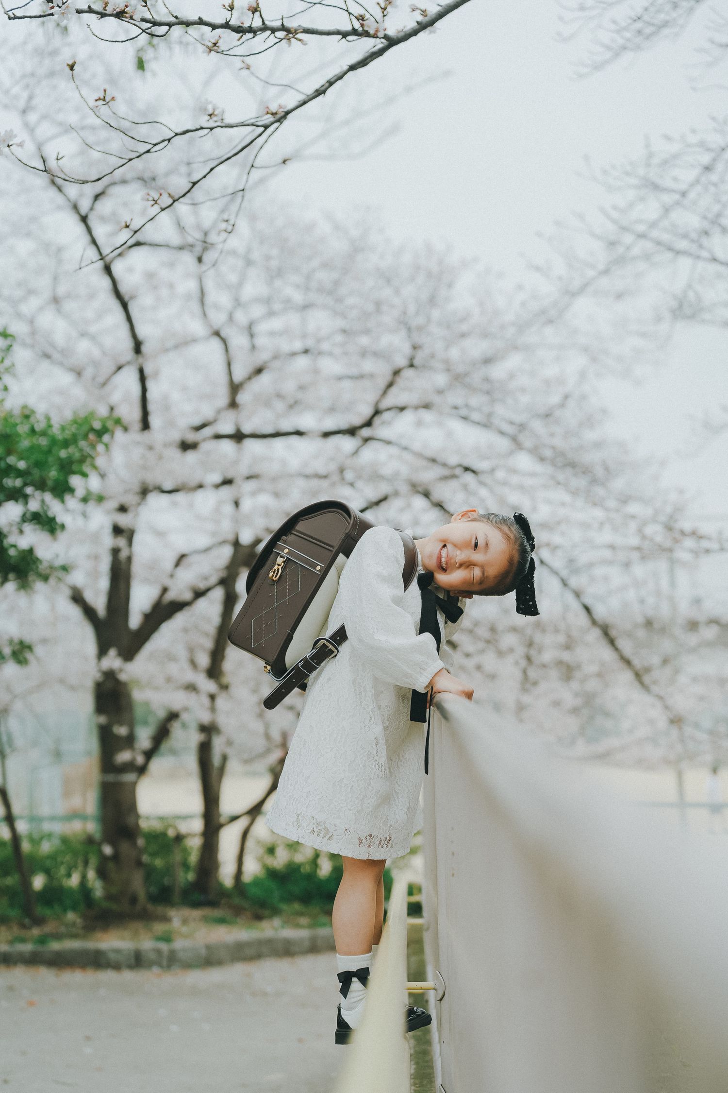 桜並木のそばで振り返る女の子のポートレート