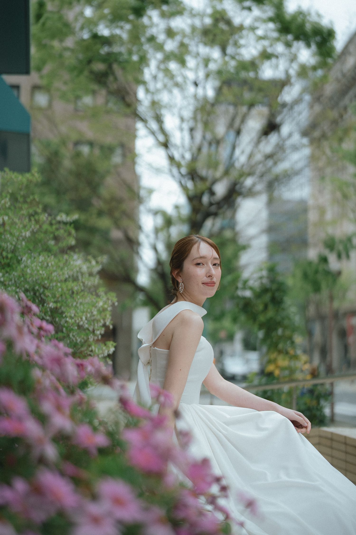 花々のそばで微笑む花嫁のやわらかなポートレート