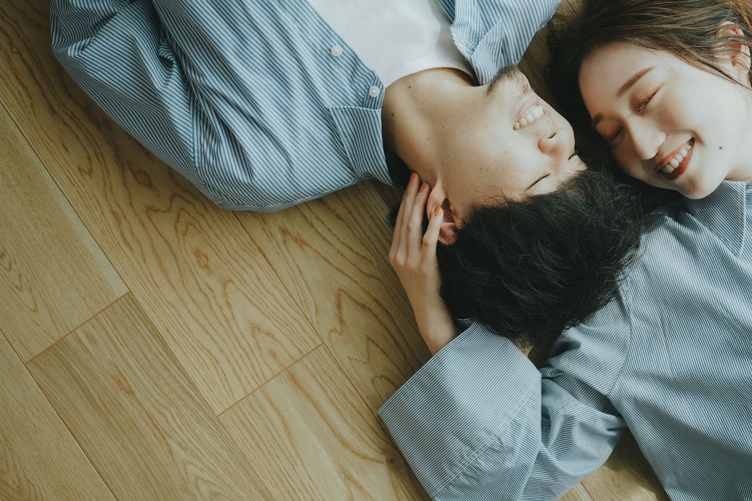床に寝転んで見つめ合うご夫婦のあたたかな一場面