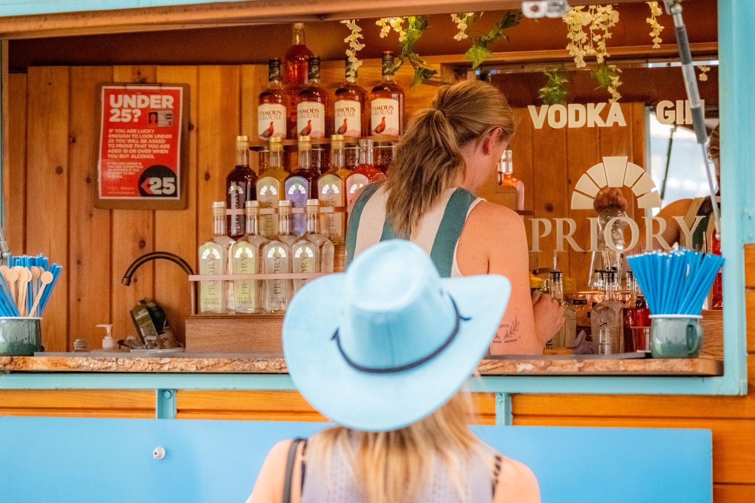 Event photograph capturing an a guest in a colour co-ordinated hat ordering a drink from Priory Vodka at The Wetherby Beer Fest 2026
