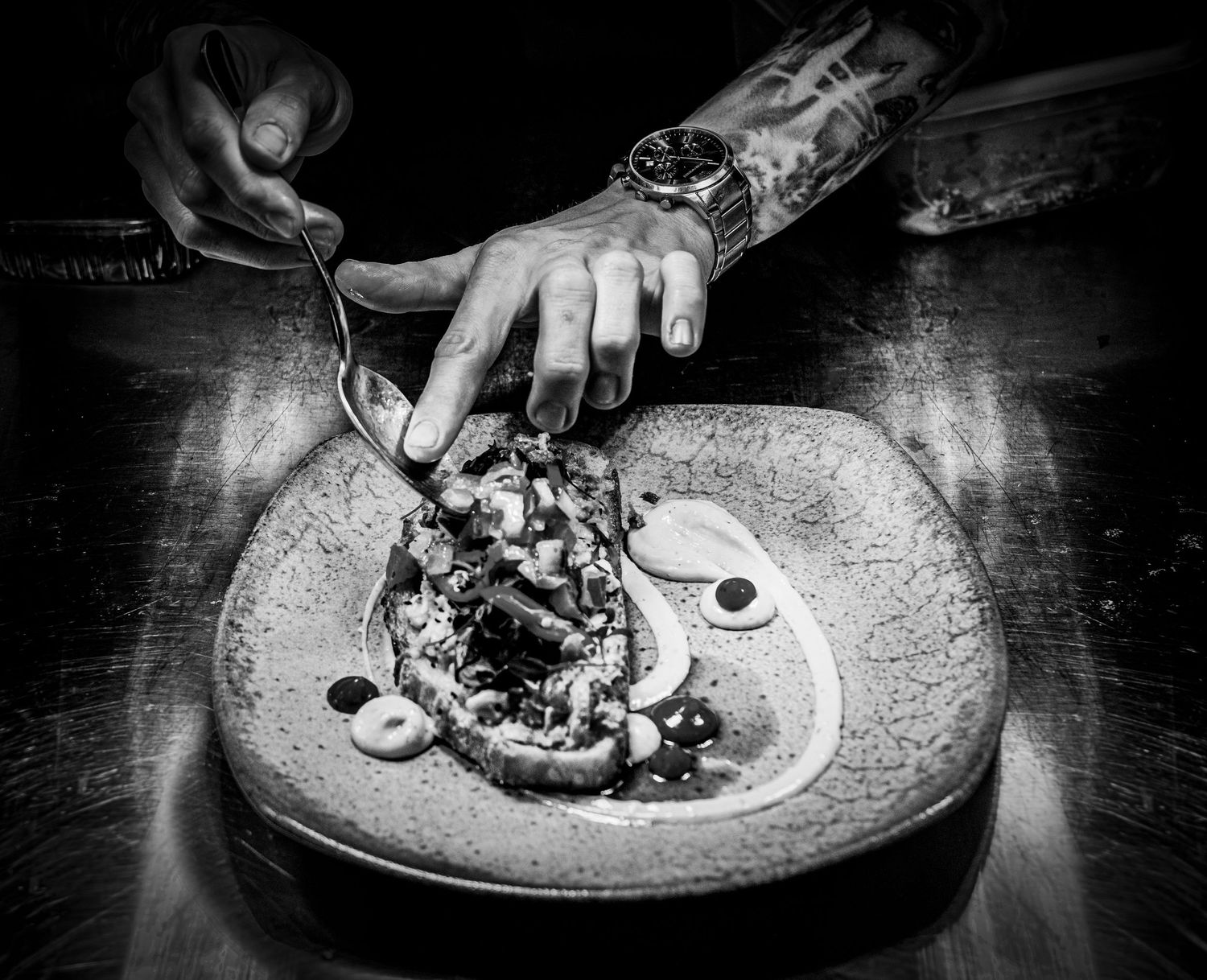 black and white photo of a chef serving food at the pass