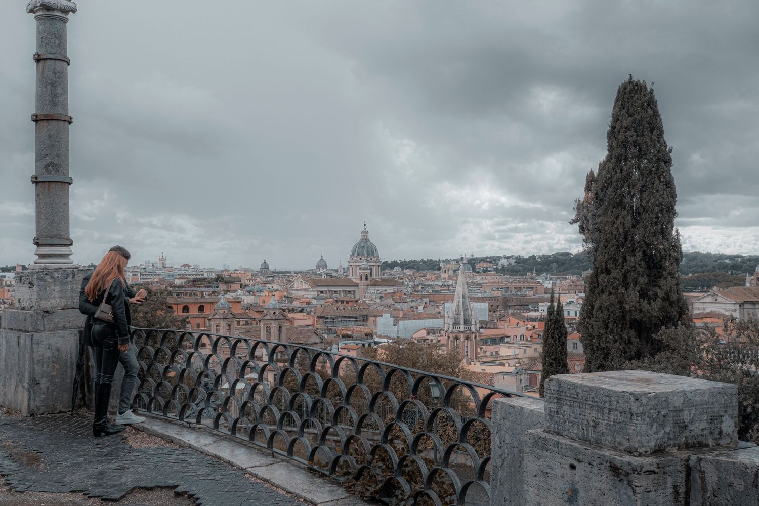 Romantic picture of a young couple newly engaged overlooking the city skyline of Rome
