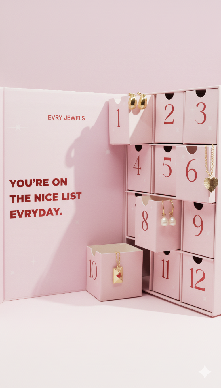 Evry Jewels 12 Days of Christmas pink advent calendar open with gold jewelry pieces displayed in numbered drawers.