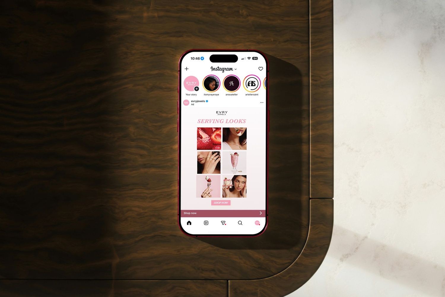 Smartphone on wooden table showing an Instagram beauty brand profile with pink aesthetic grid posts.