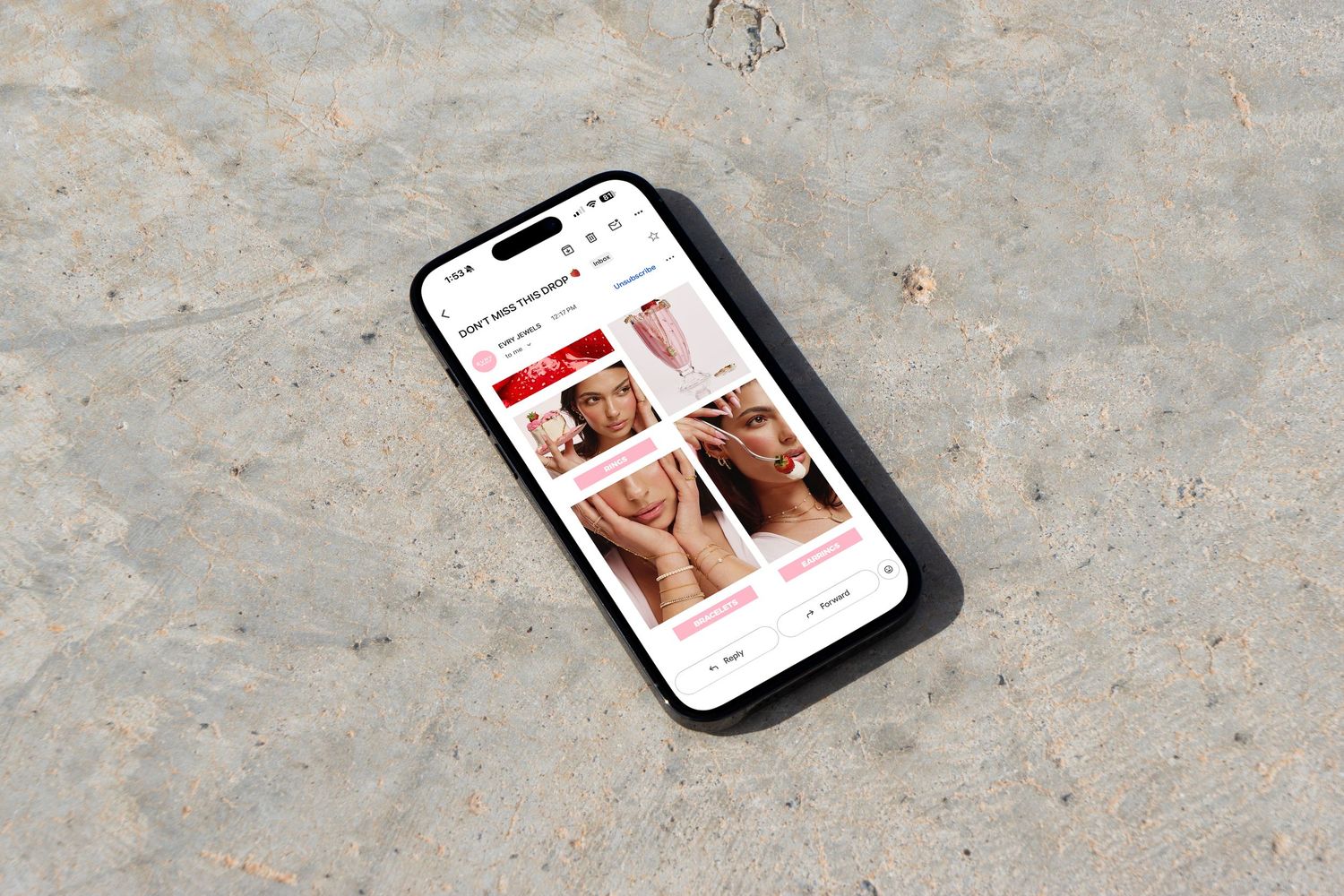 Smartphone lying on sand showing a beauty e-commerce website with skincare product grid layout.