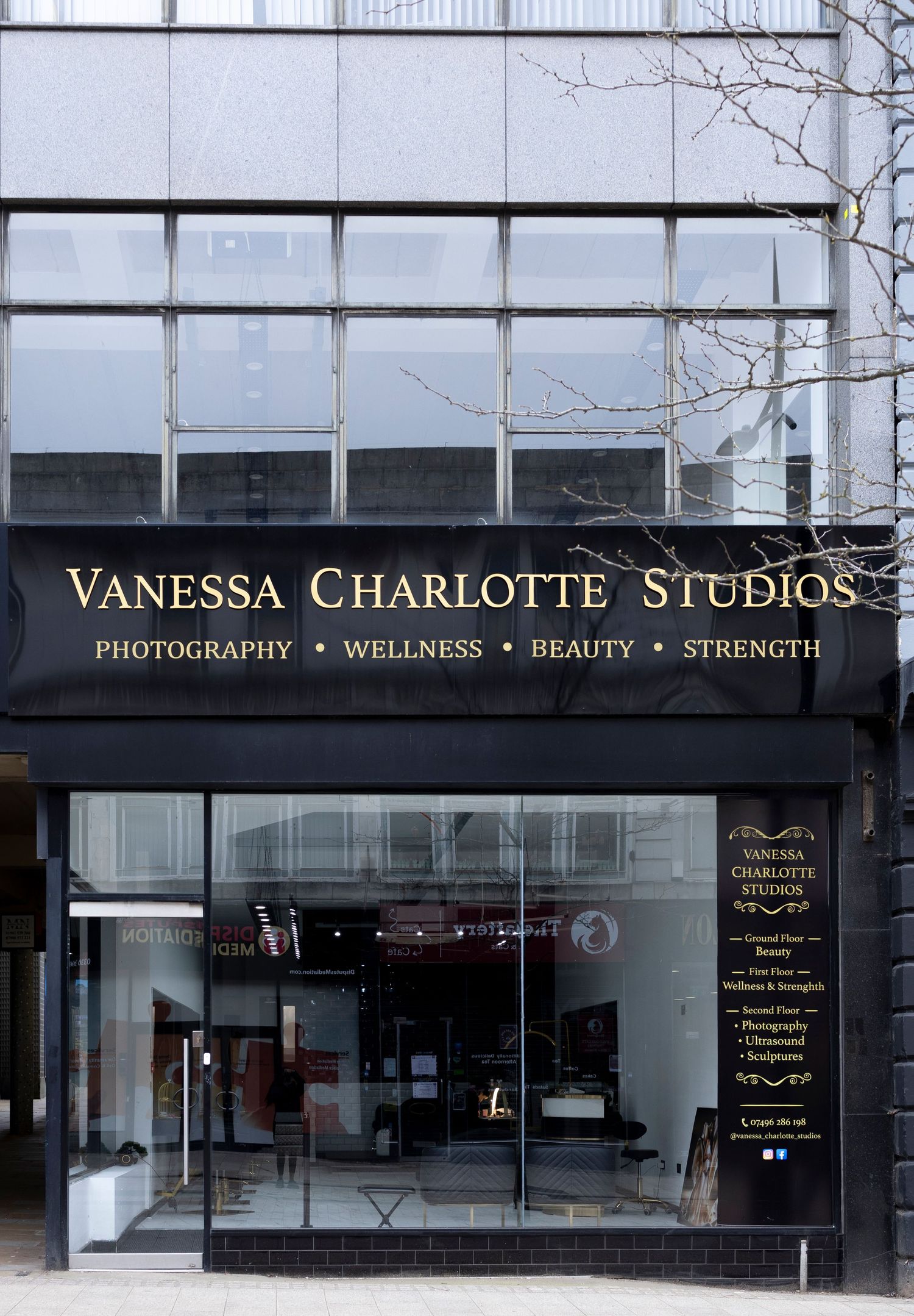 Vanessa Charlotte Studios storefront offering photography, wellness, beauty, and strength services in a modern building.