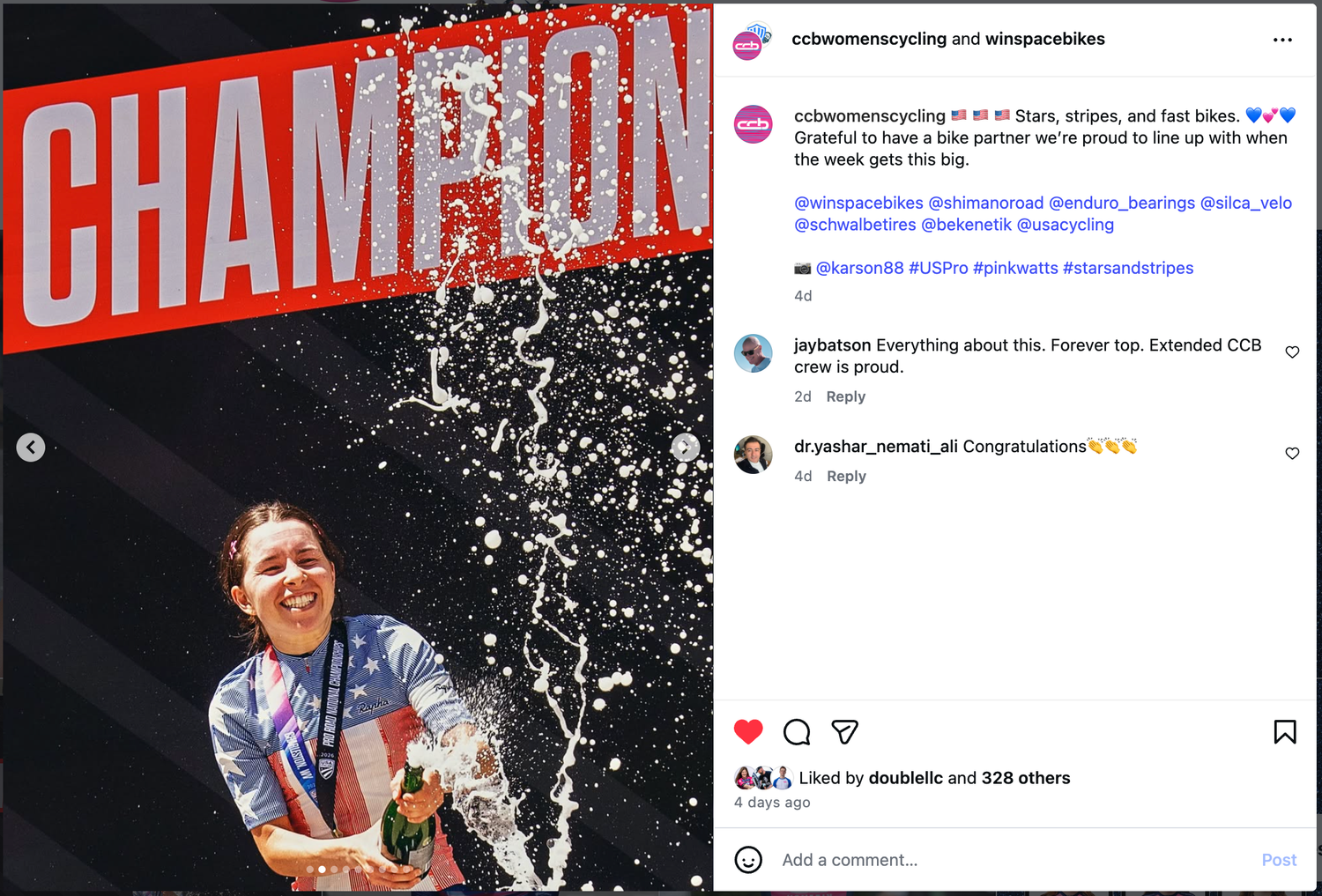 Cyclist celebrates championship victory with champagne spray, wearing medals and raising arms in triumph at cycling competition.
