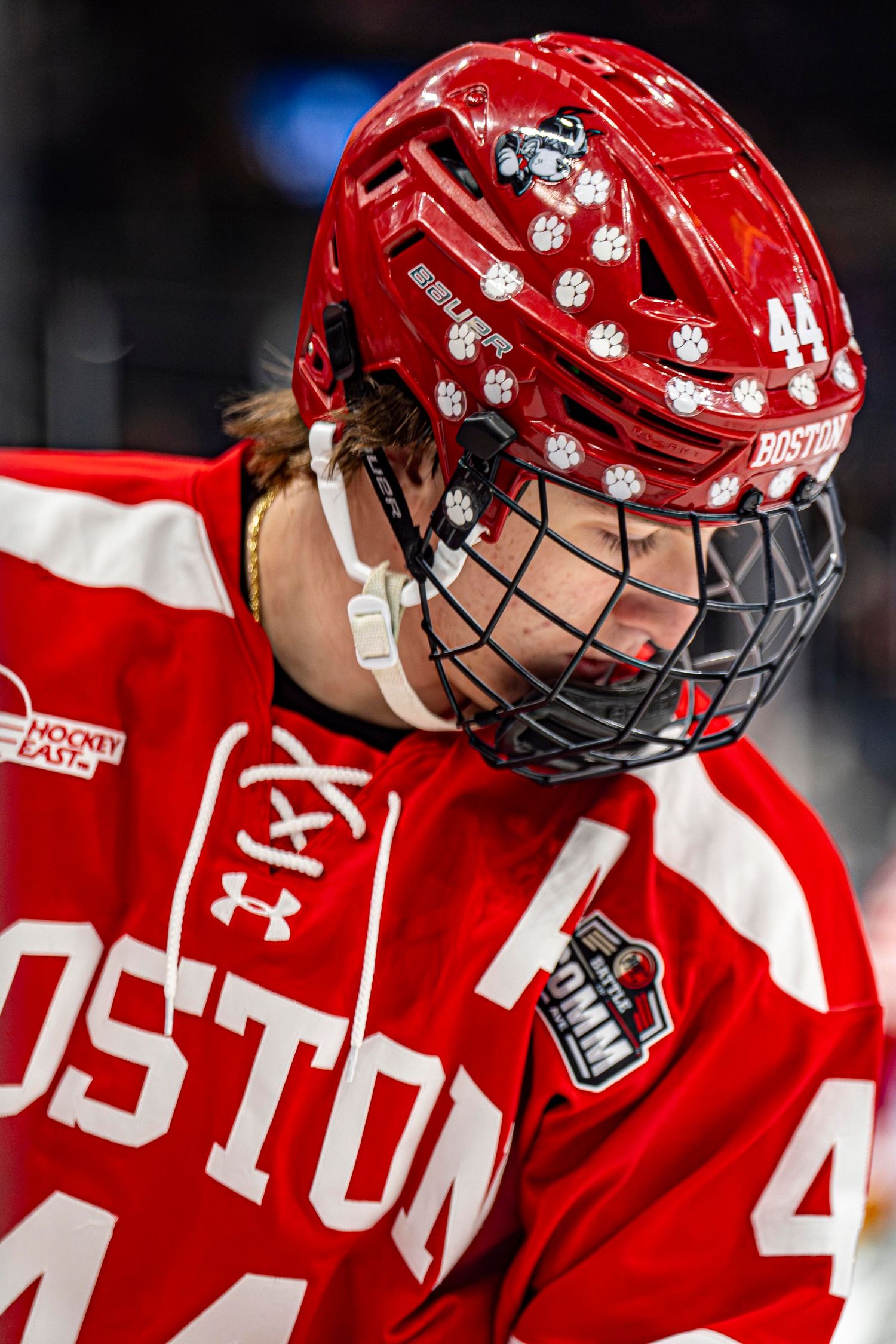 Boston University hockey player #44 wearing a red helmet and jersey during a Hockey East game.