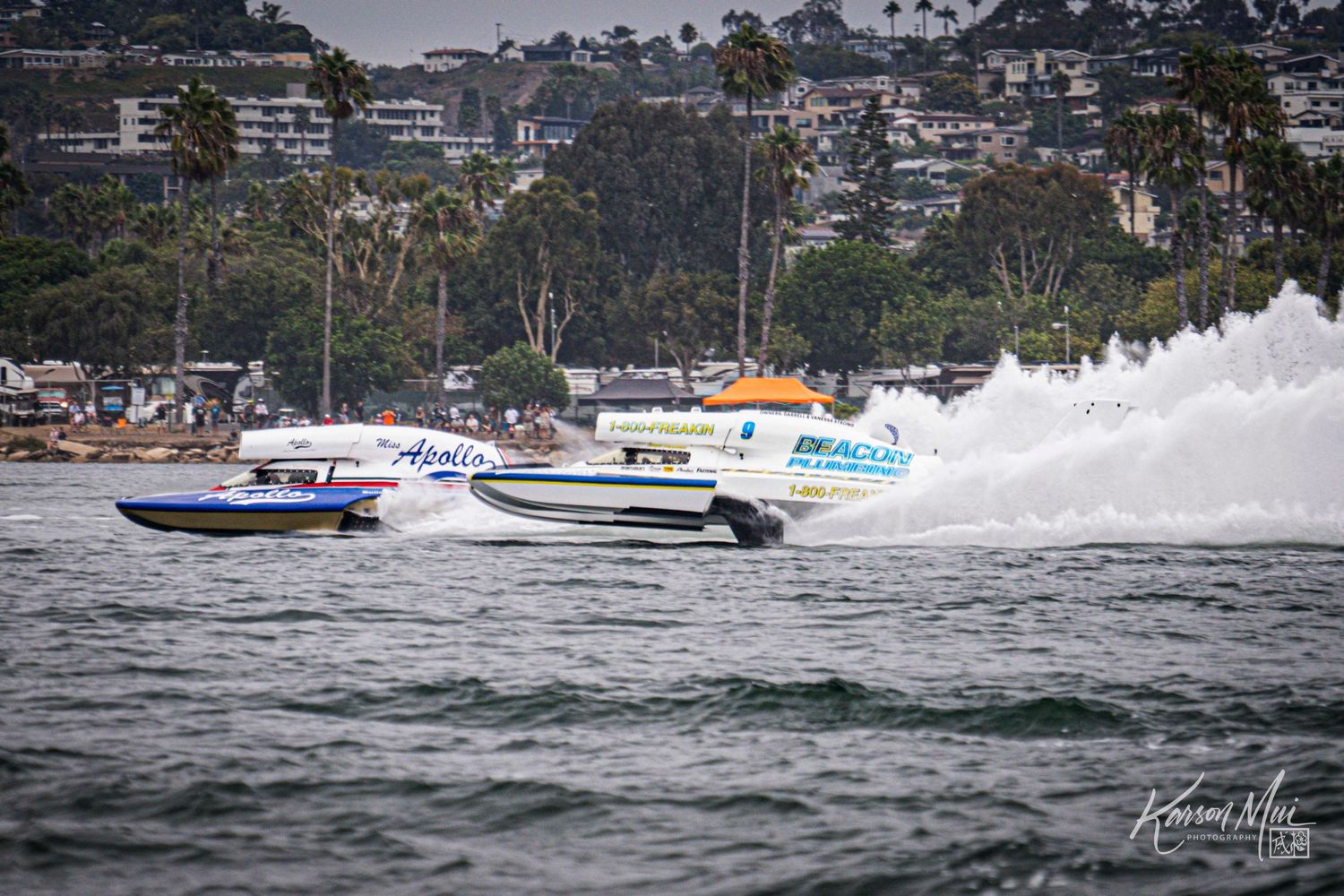 Multiple powerboats including Apollo and DrPacific race across open water during a competitive offshore boat race.