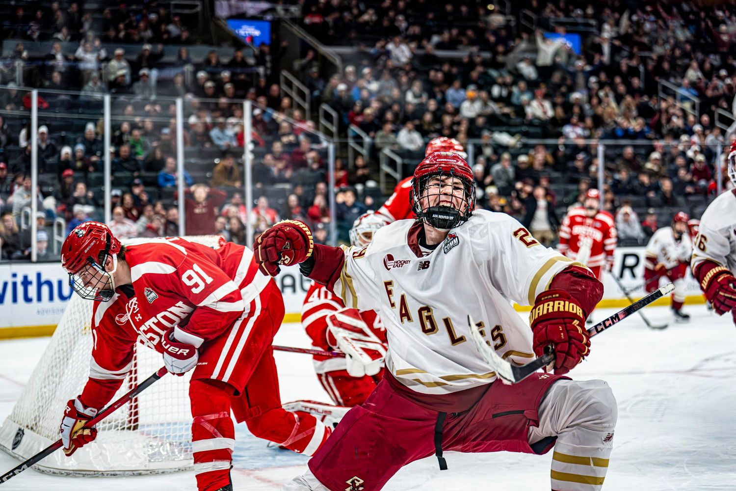 Boston College Eagles hockey player battles near goal during intense college hockey game.