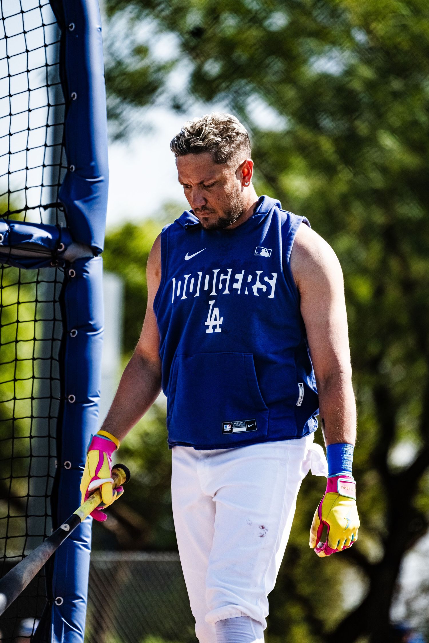 Los Angeles Dodgers player in blue sleeveless jersey and white pants holding a bat during batting practice.