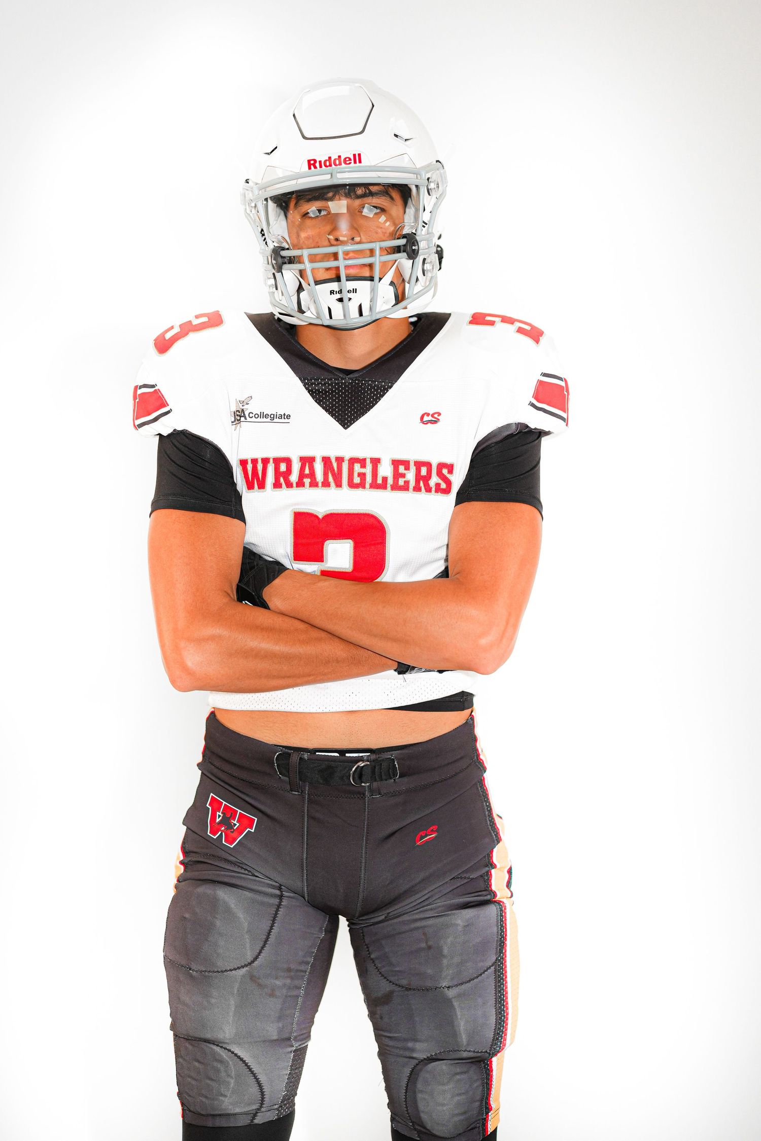 Football player in Wranglers uniform #2 wearing Riddell helmet, arms crossed, posing against white background.