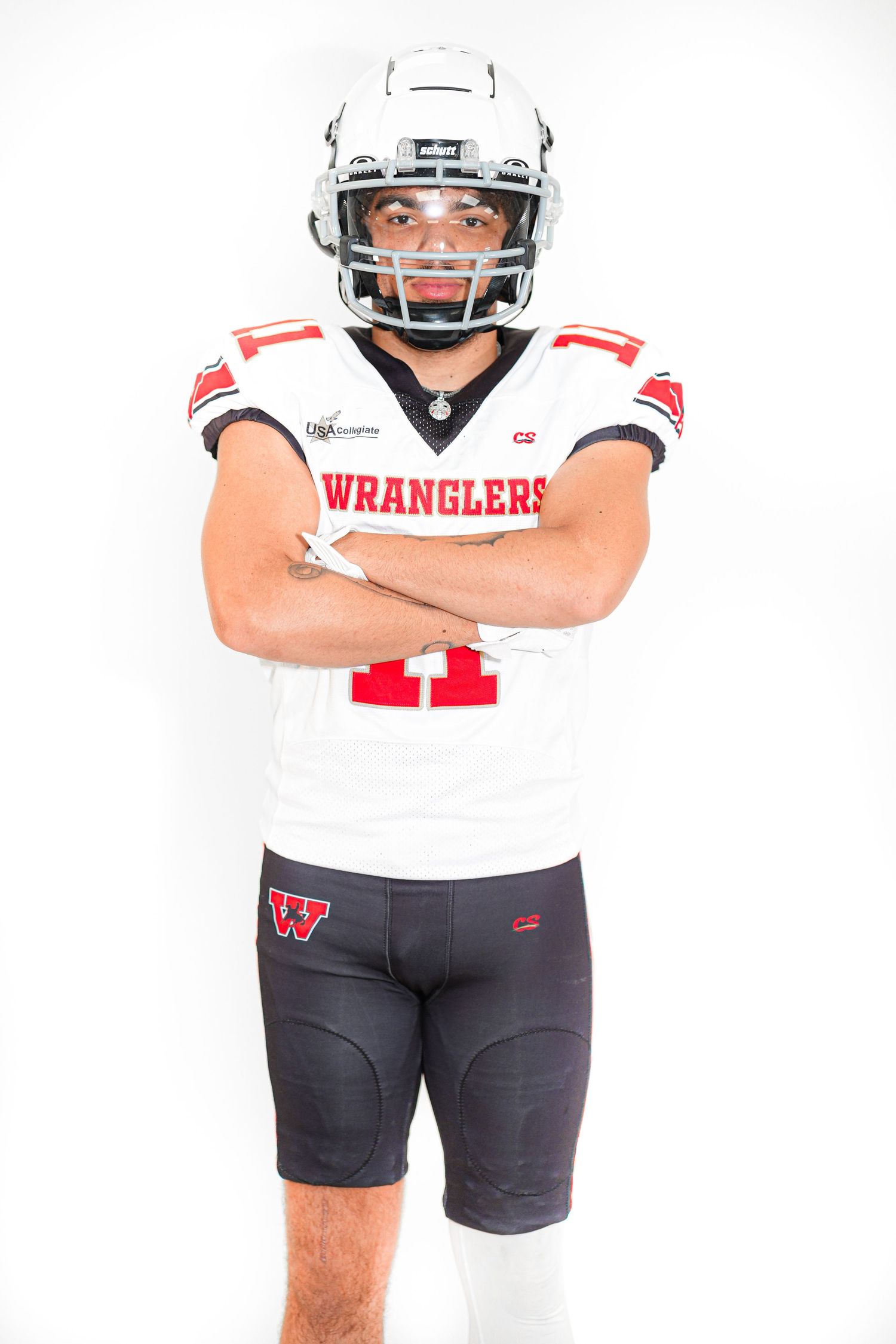 Football player in white Wranglers jersey number 11 poses with arms crossed wearing helmet and dark compression shorts.