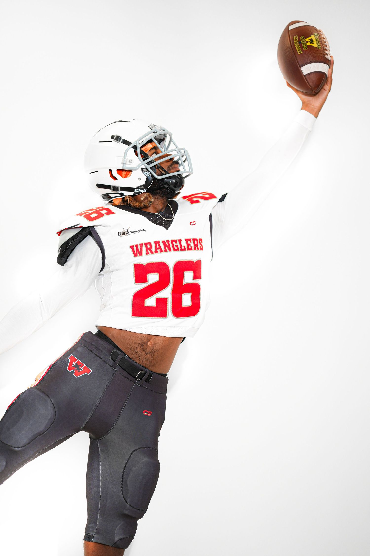 Wranglers football player #26 in white uniform raises football overhead in dynamic studio pose.