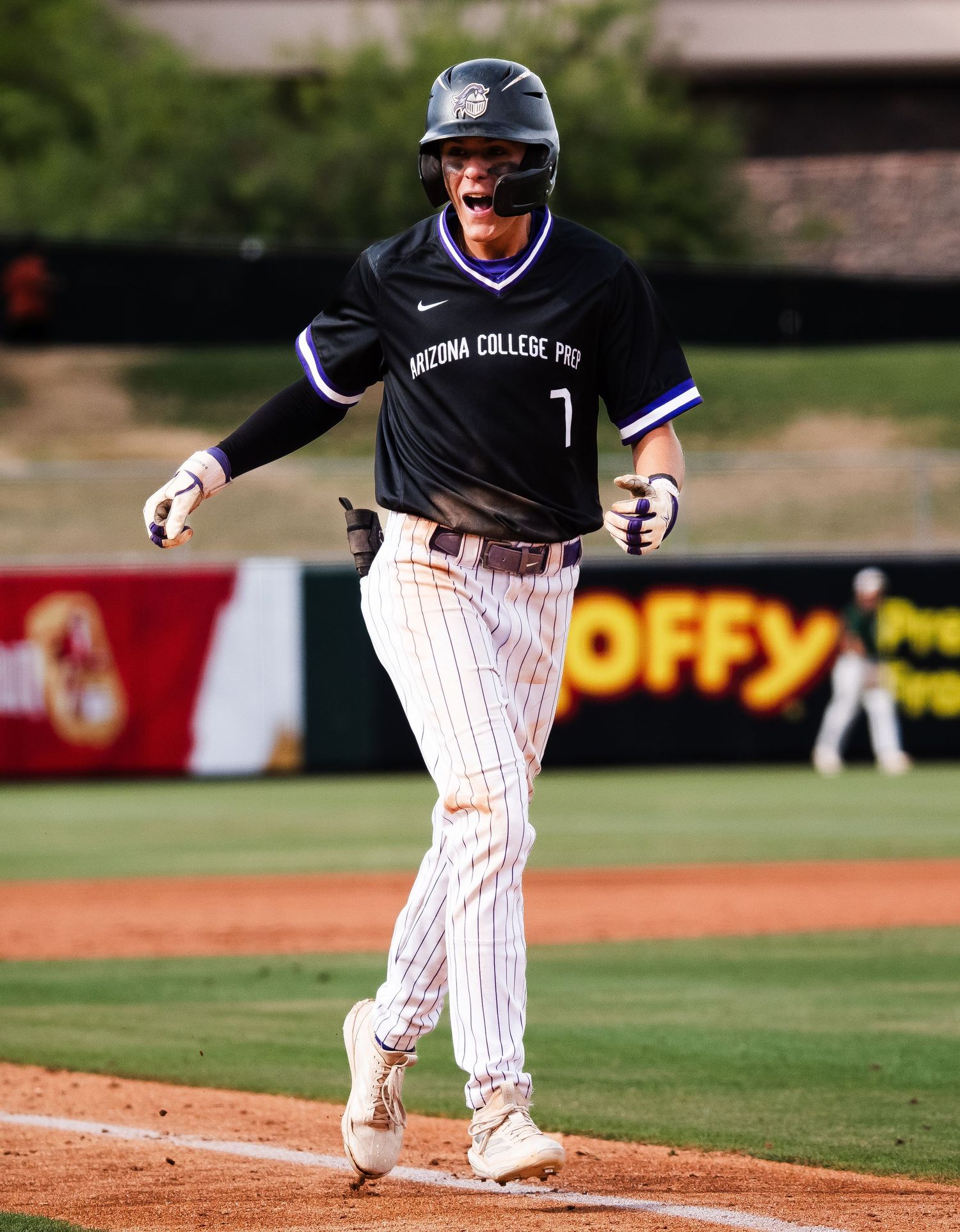 Arizona College Prep baseball player number 7 celebrates enthusiastically while running the bases.