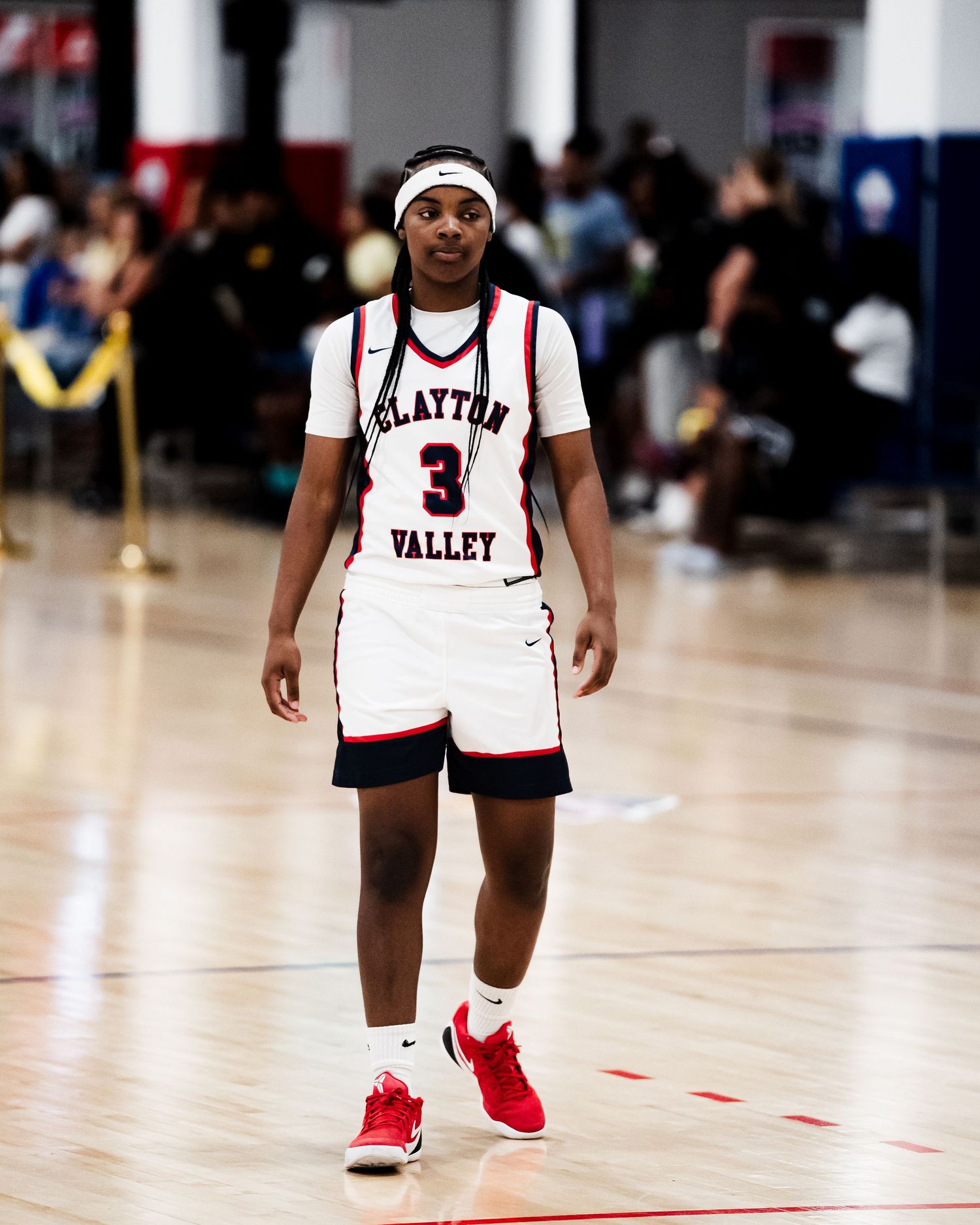 Clayton Valley basketball player #3 in white uniform walks on court during a game.