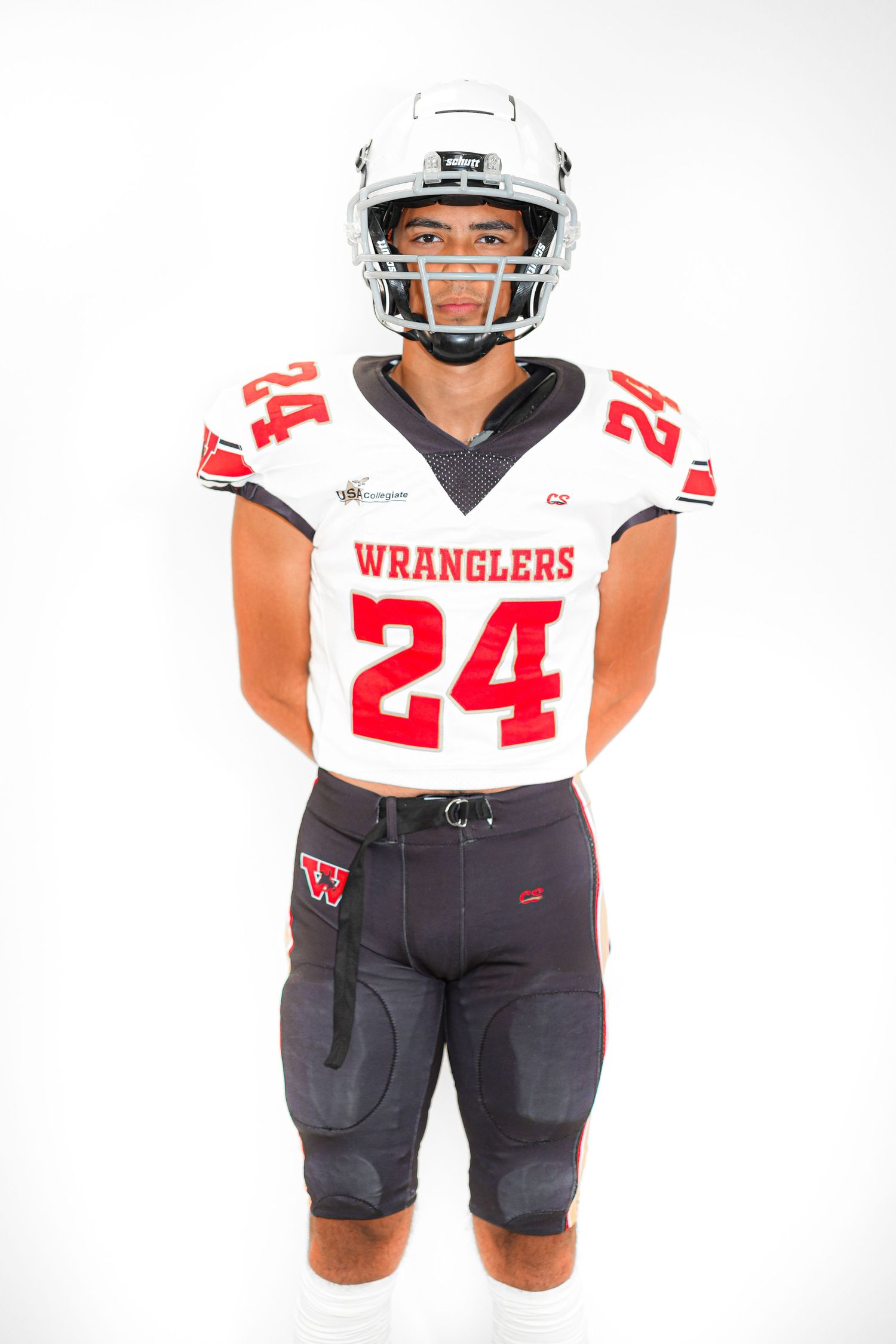Football player #24 in white Wranglers uniform and helmet stands in studio.