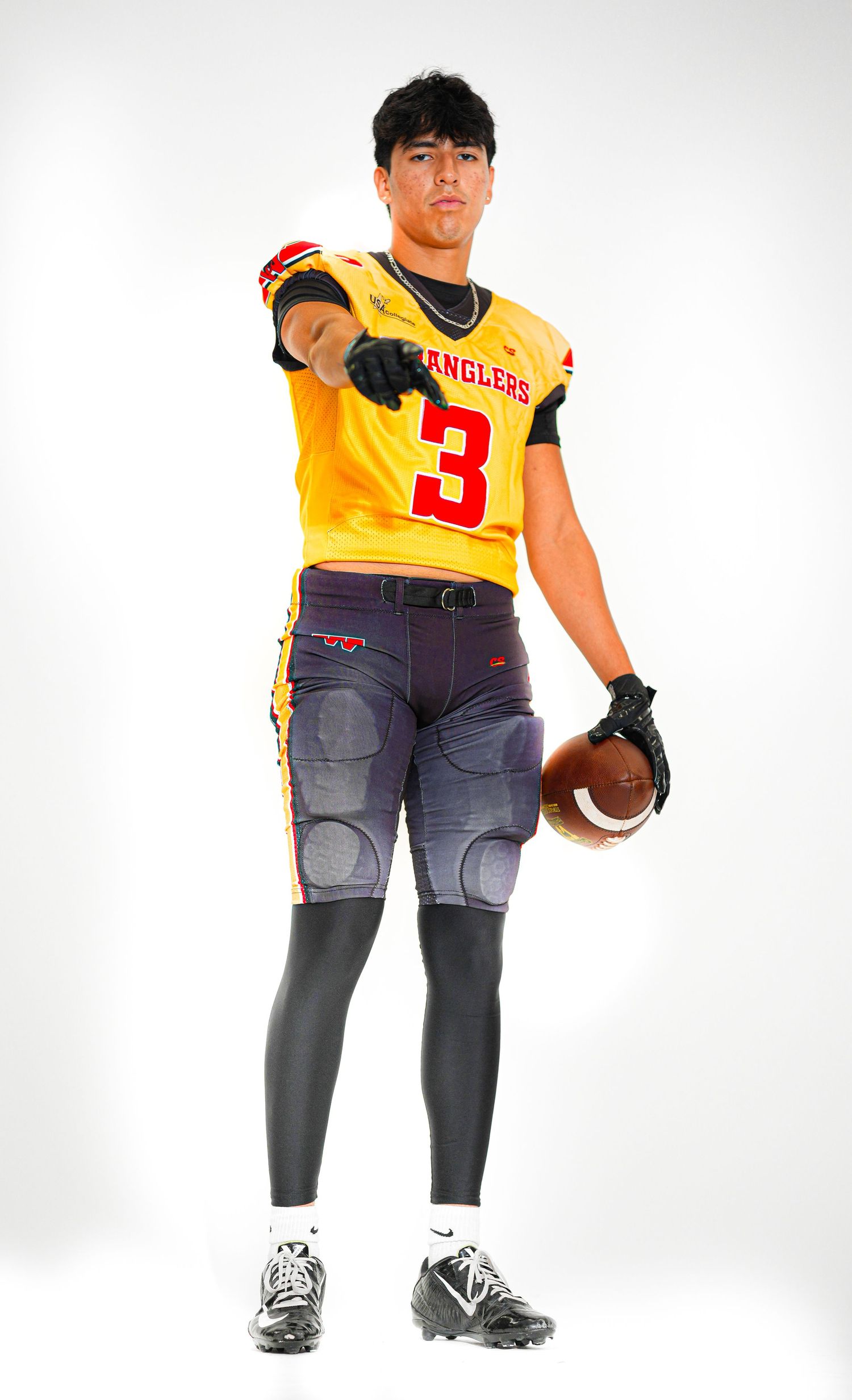 Wranglers football player #3 in gold jersey pointing at camera while holding a football in a studio photo.