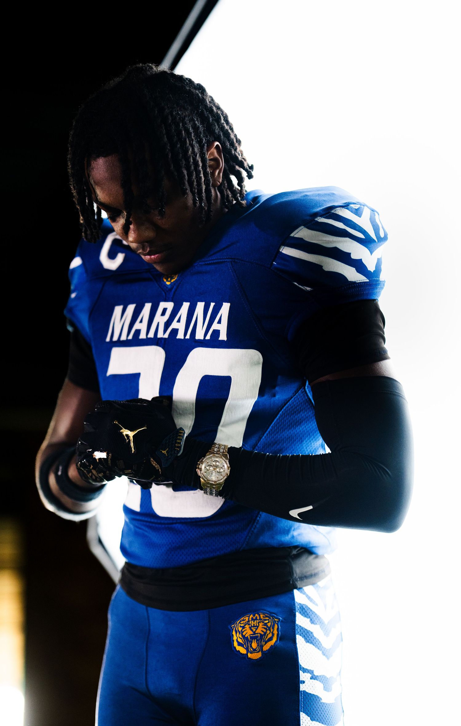 Marana Tigers football player in blue uniform with Jordan logo and captain patch, looking down dramatically.