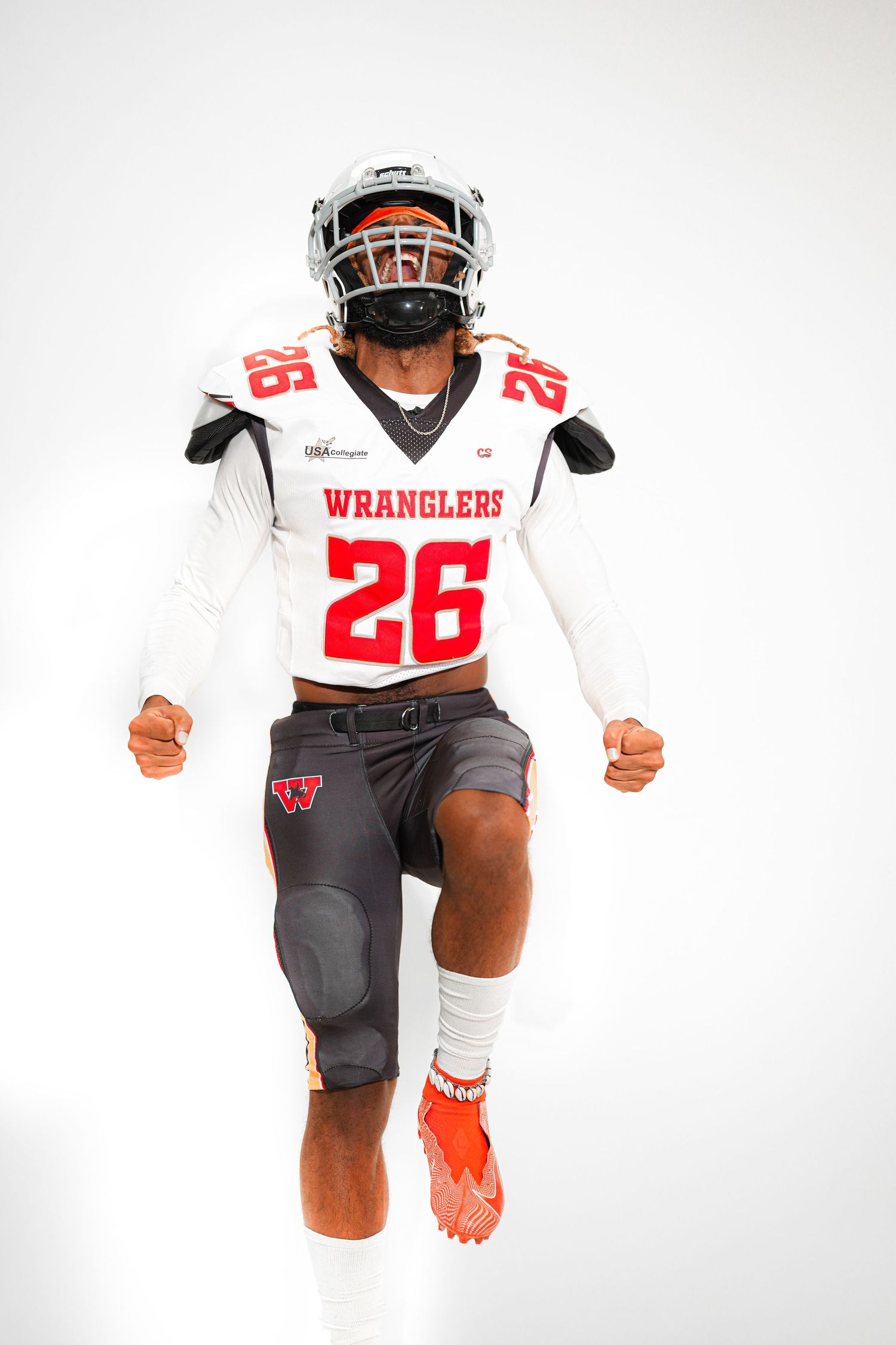 Football player in white Wranglers jersey number 26 jumping mid-air in full uniform with helmet on white background.