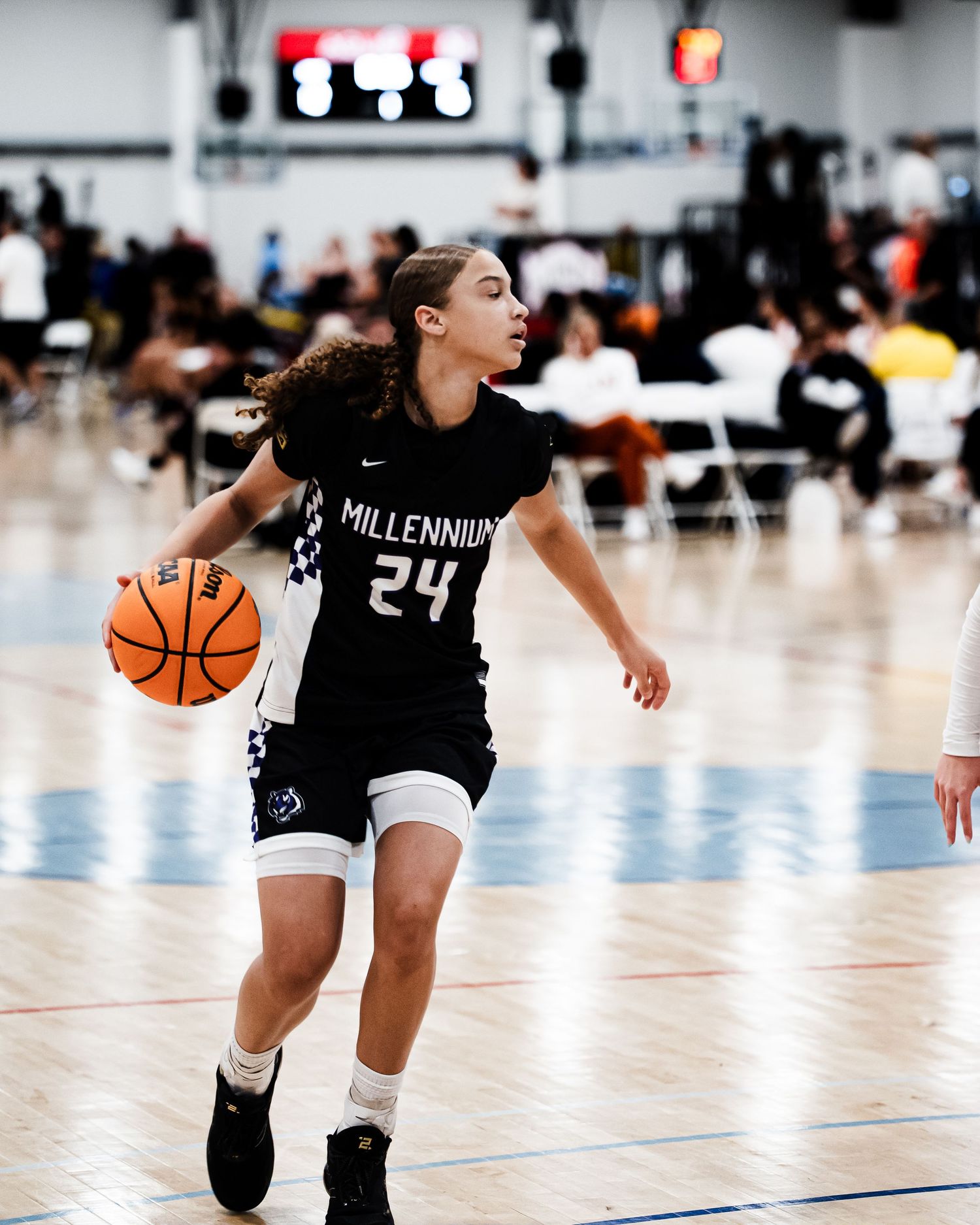 Millennium #24 dribbles the ball during a girls high school basketball game.