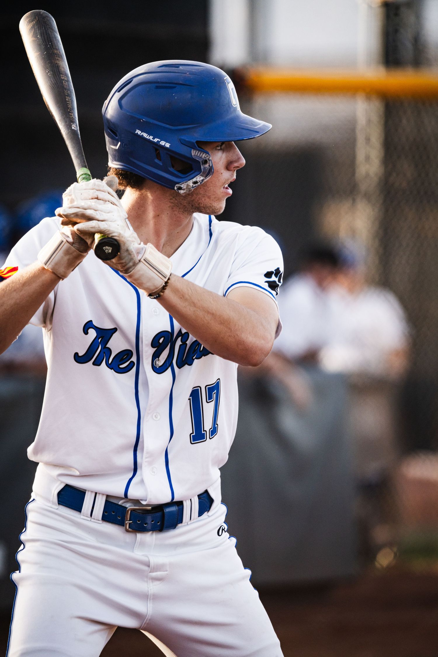 Baseball player #17 in blue helmet and white uniform stands ready at bat during a game.