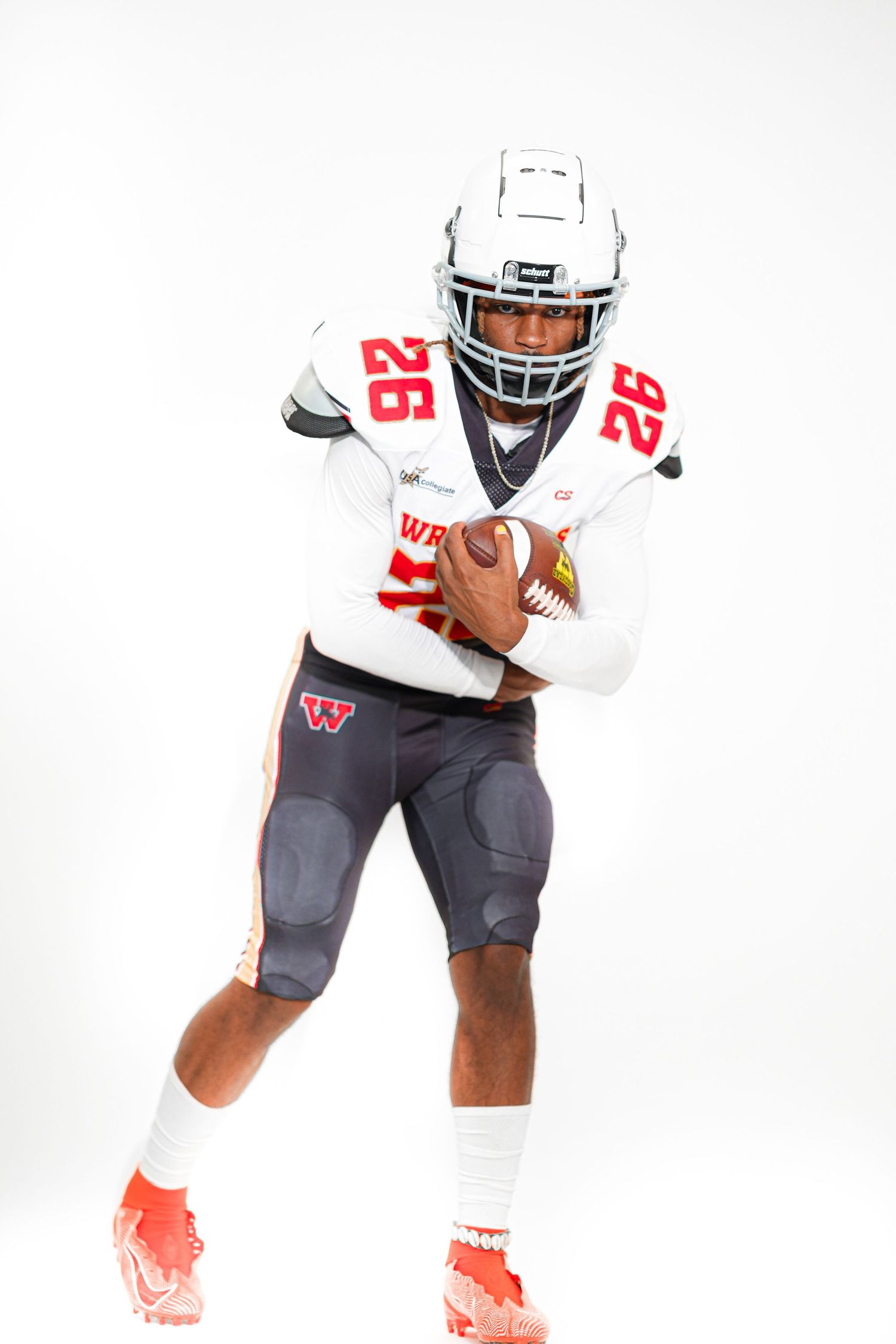 Football player #26 in white uniform holding ball in running stance on white background.