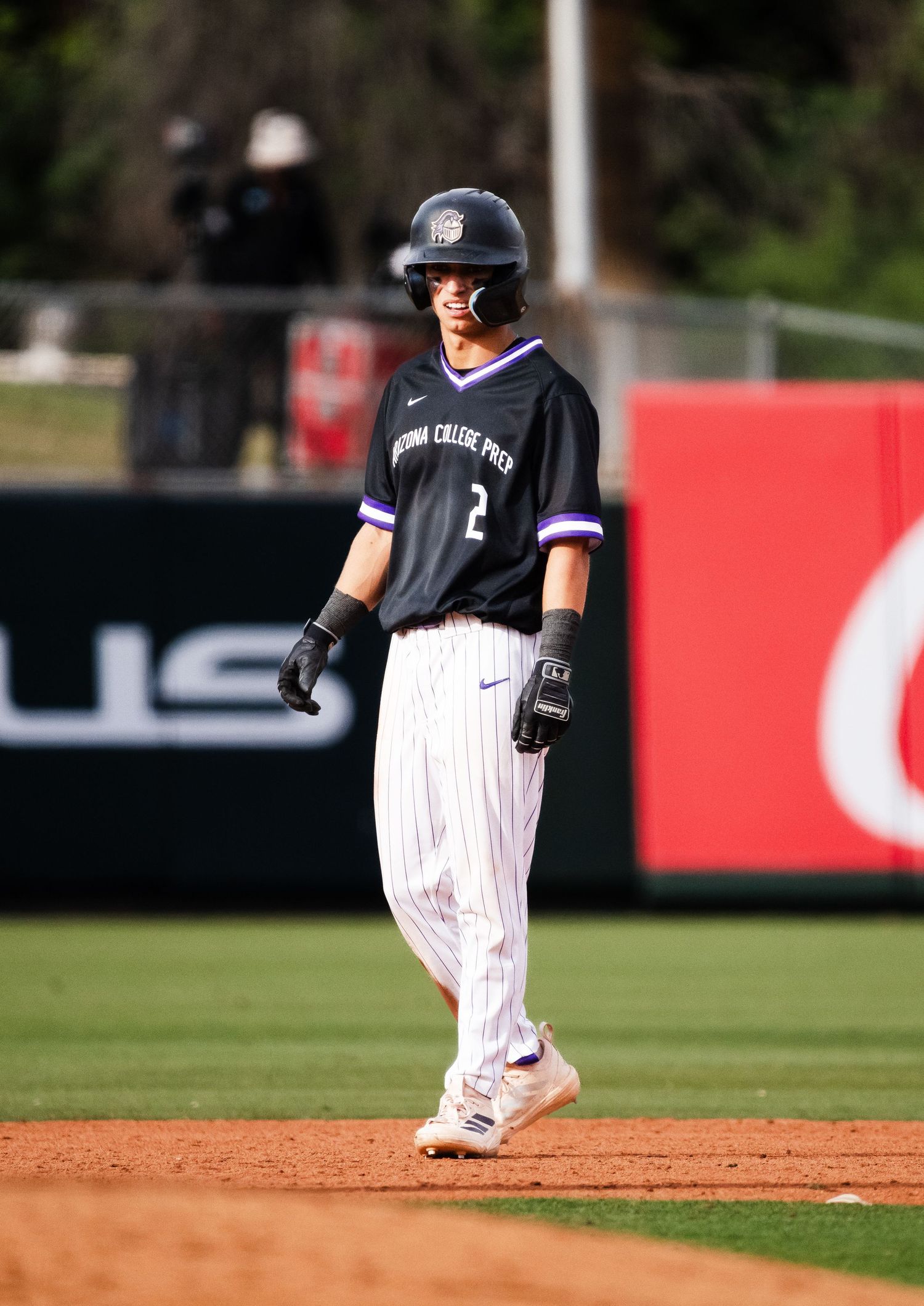 Baseball player #2 in black pinstripe uniform standing on base during a college baseball game.