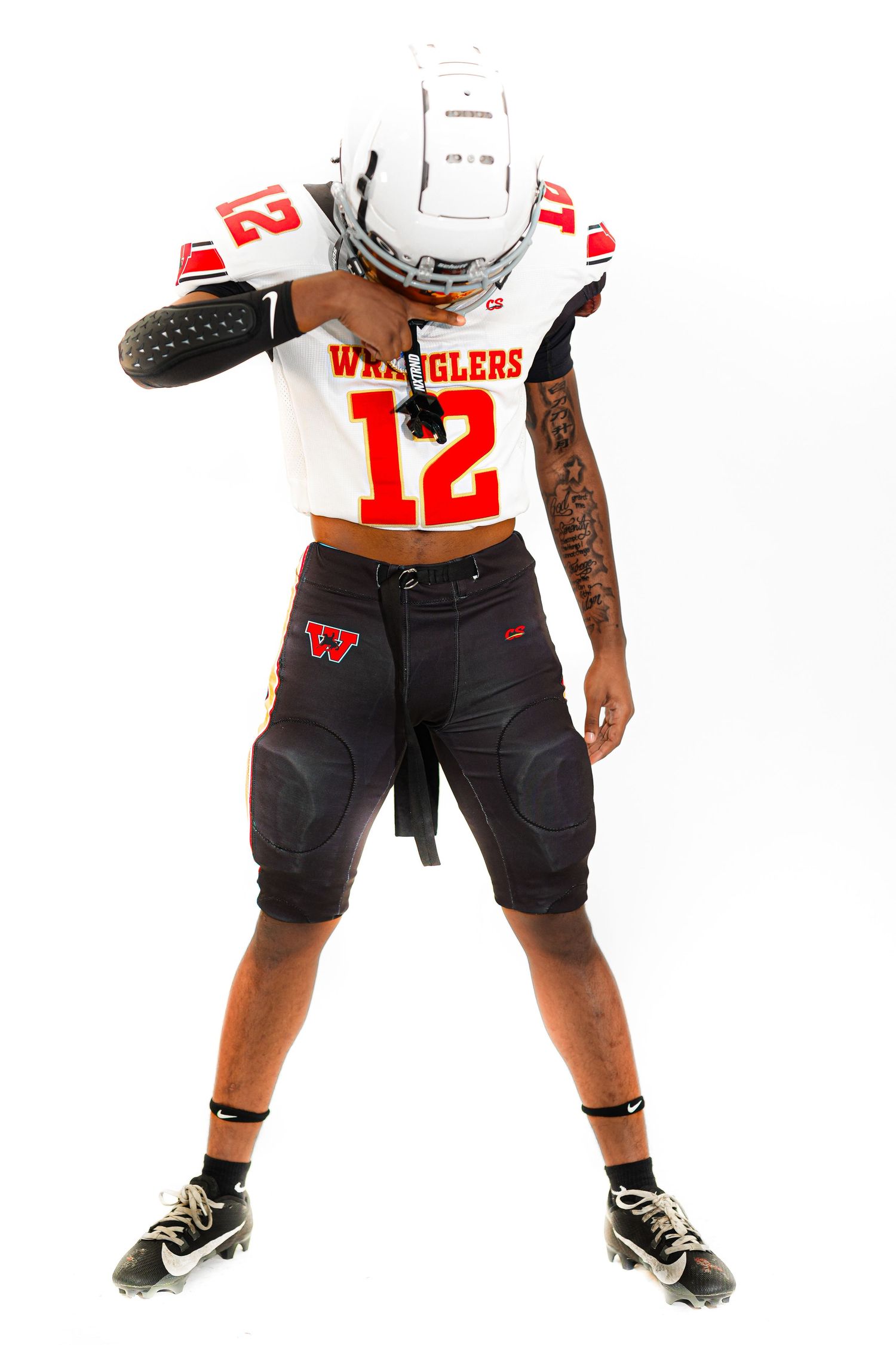 Football player wearing Wranglers #12 white jersey and black shorts poses in full uniform with helmet on white background.