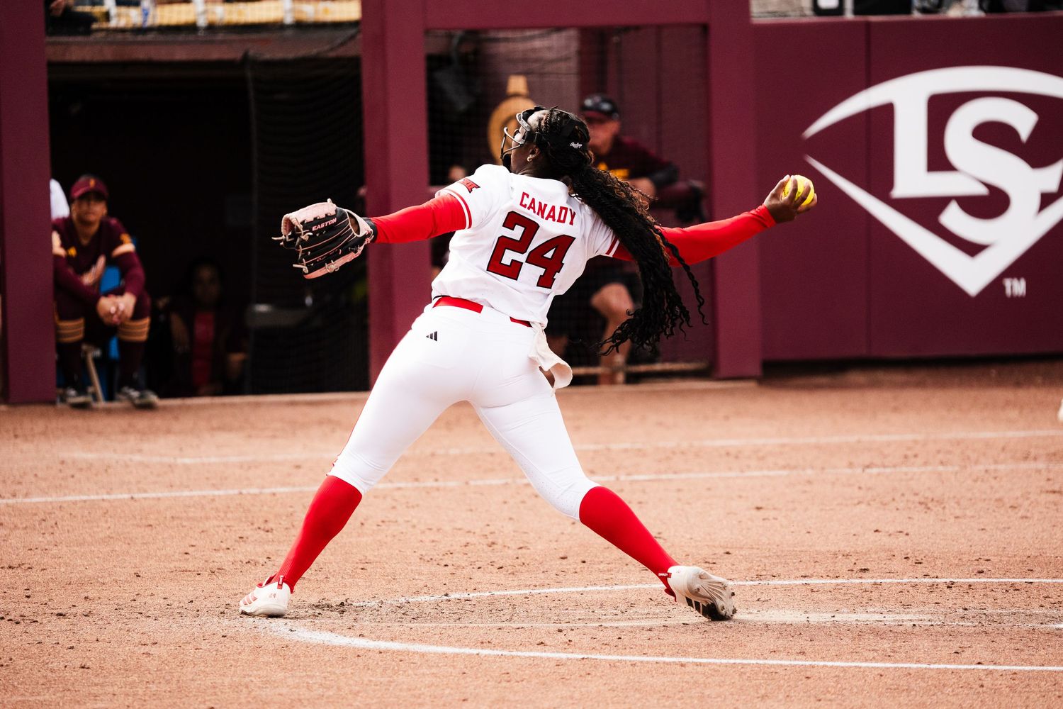 Texas Tech softball player #24 pitching in red and white uniform during a college softball game.