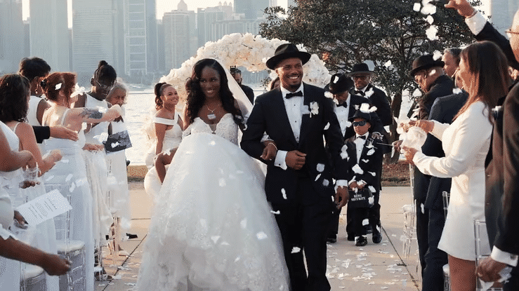 Bride and groom posing by the water with a soft Chicago skyline backdrop, captured in a timeless, modern portrait by Noelle Moss Photography