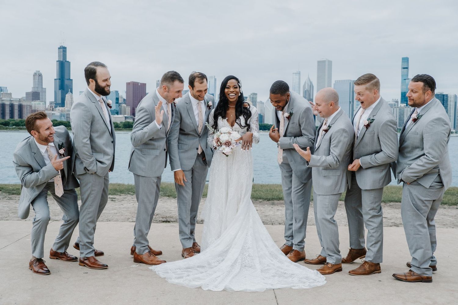 Bride and groom posing by the water with a soft Chicago skyline backdrop, captured in a timeless, modern portrait by Noelle Moss Photography