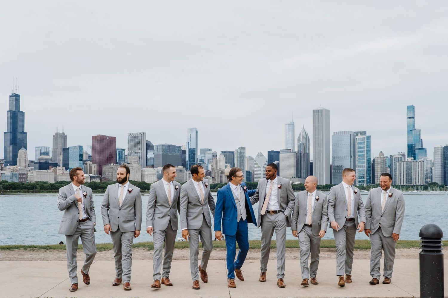 Bride and groom posing by the water with a soft Chicago skyline backdrop, captured in a timeless, modern portrait by Noelle Moss Photography