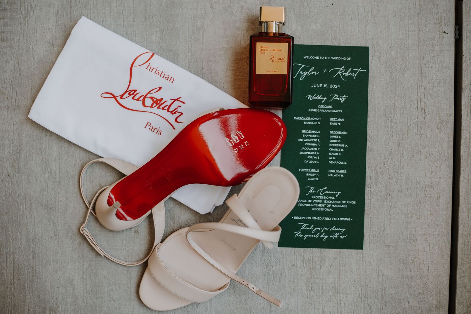 Wedding invitation flat lay with perfume, shoes, and floral details captured by Noelle Moss Photography