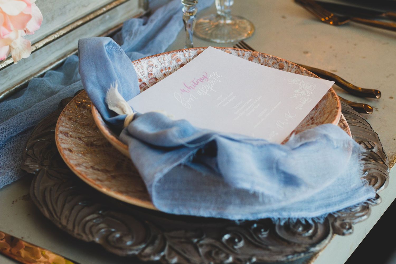 Wedding invitation flat lay with perfume, shoes, and floral details captured by Noelle Moss Photography