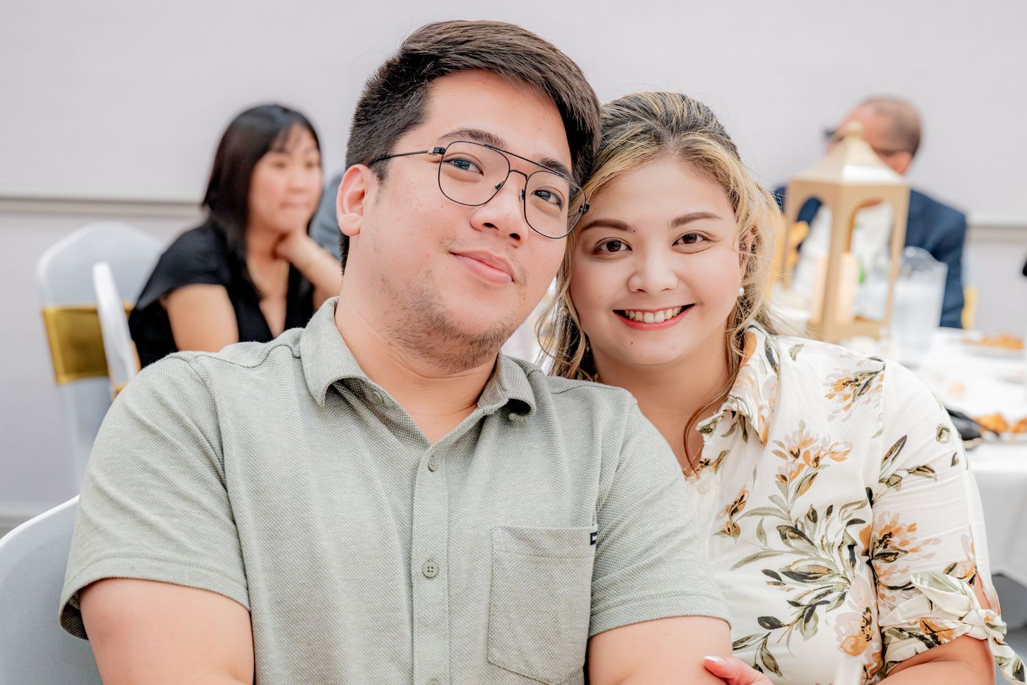 Young couple smiling and posing together at an indoor event.